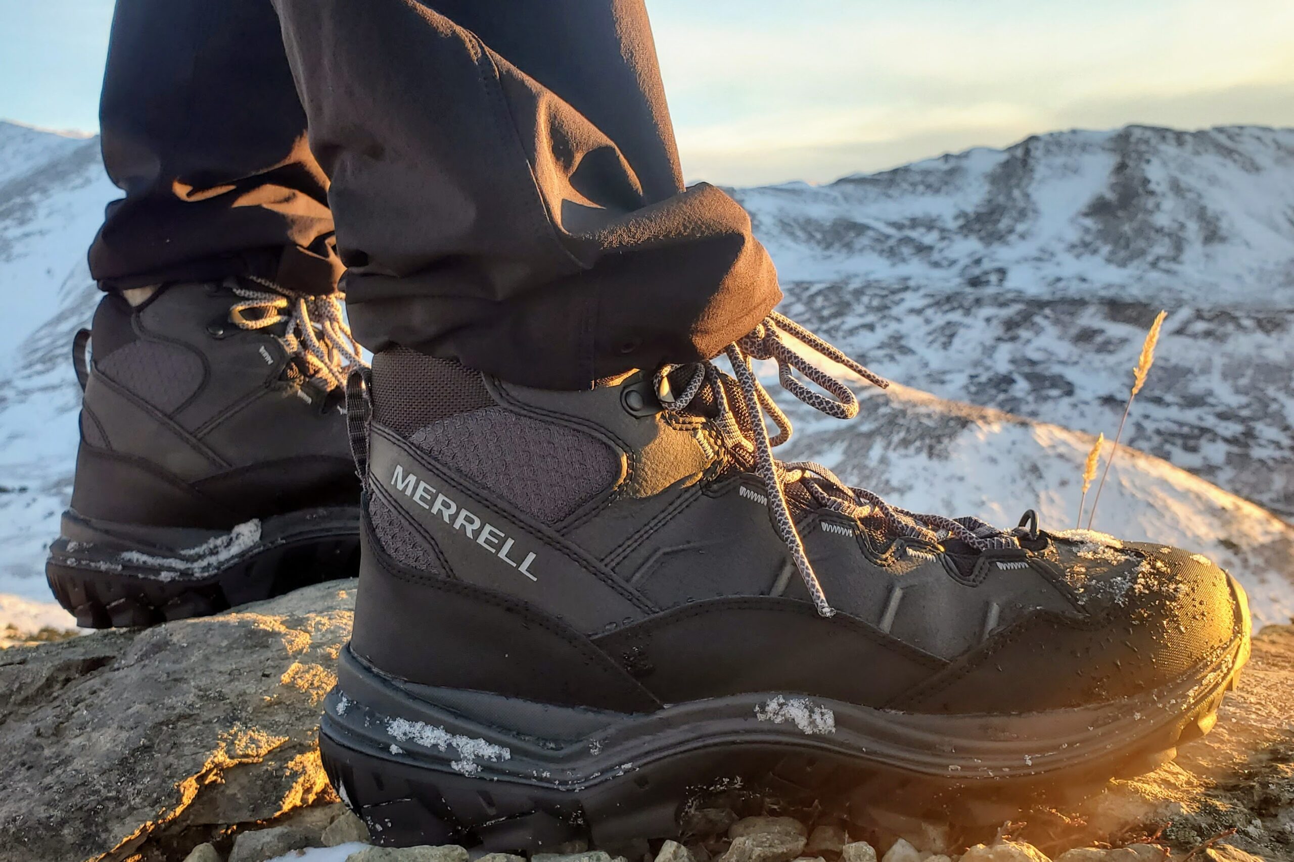 A side shot of the outside of hiking boots at sunset.