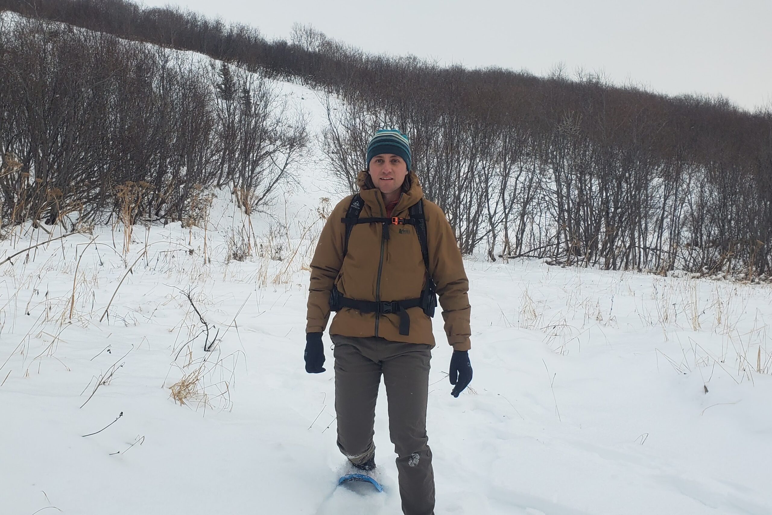 A man snowshoes through a meadow