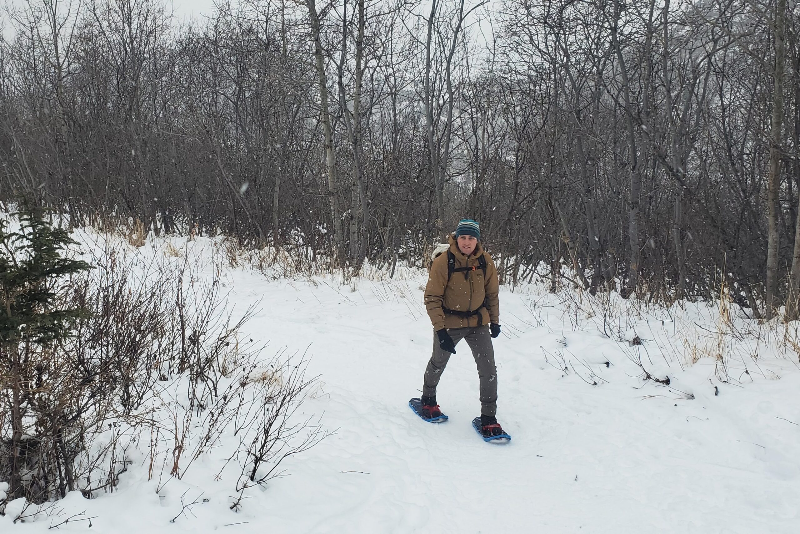 A man walks up a winter trail