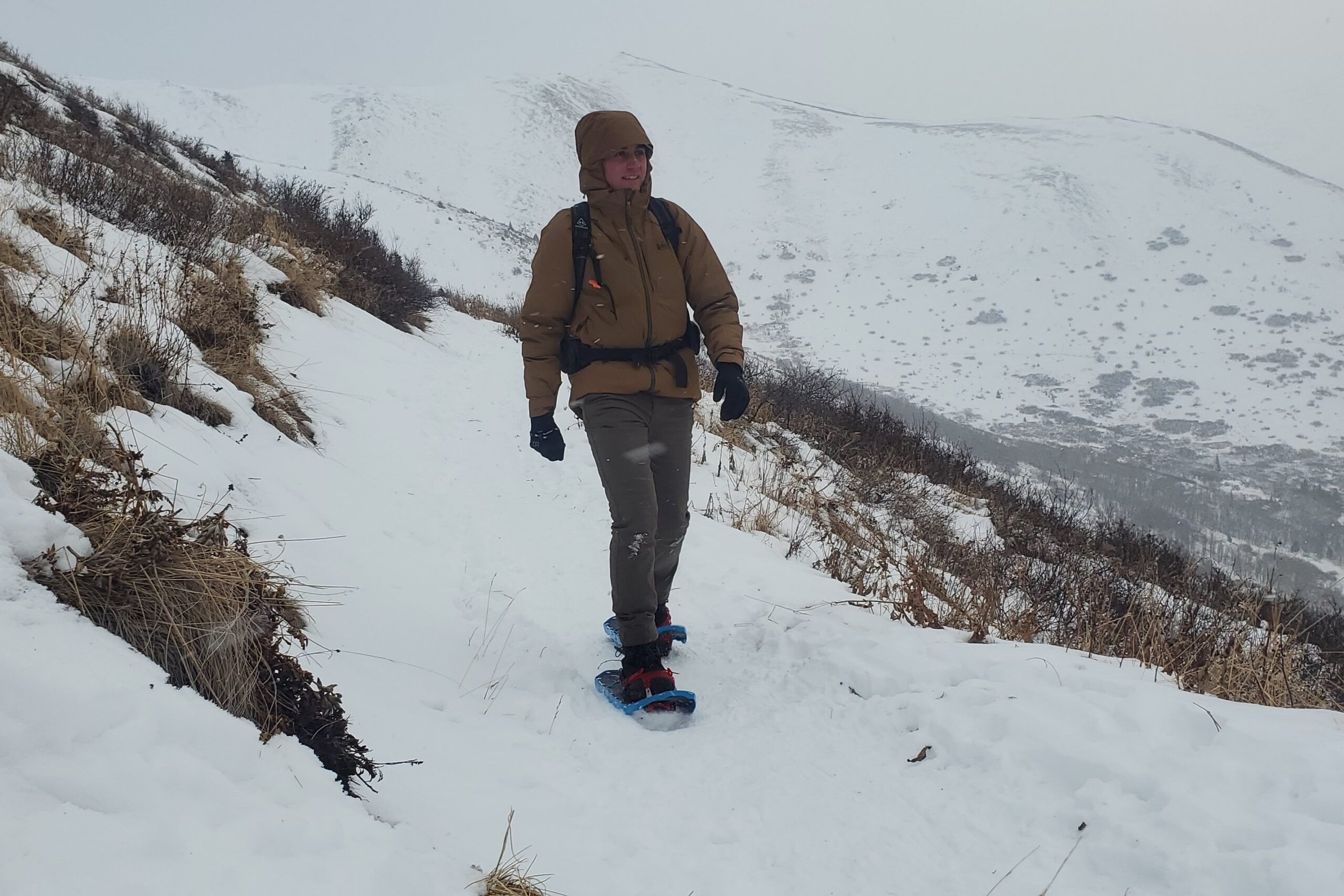 A man snowshoes along a winter trail