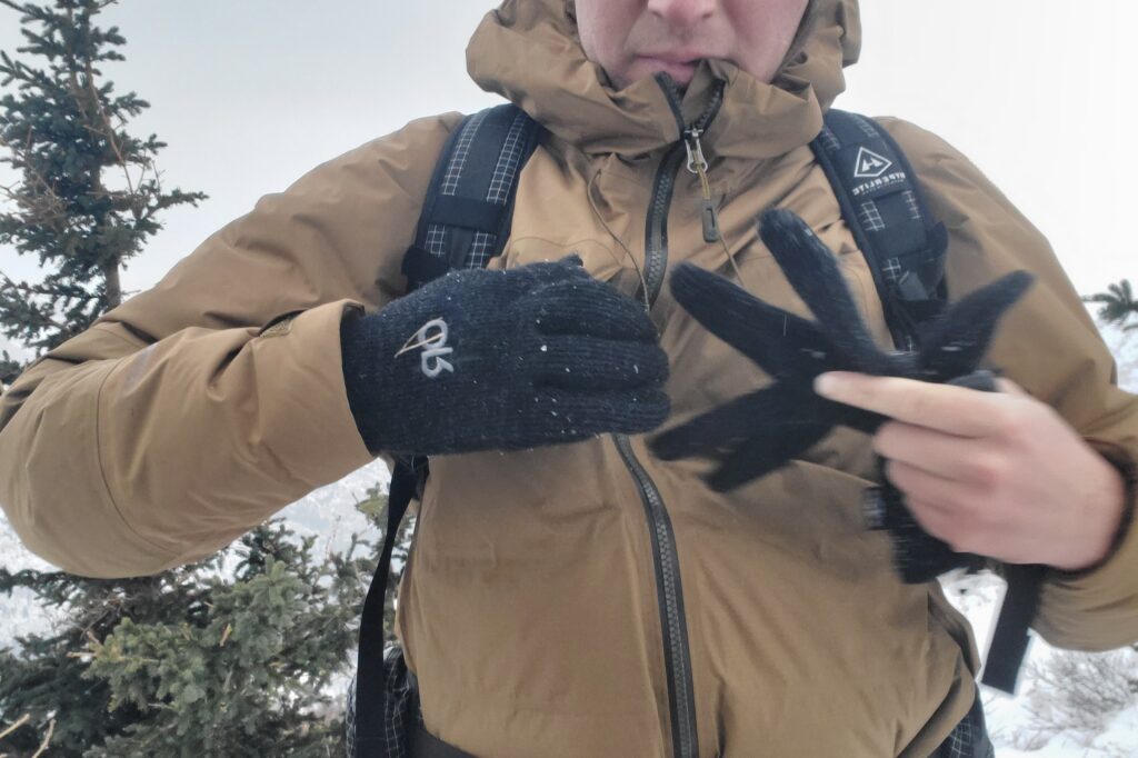 A man removes a pair of wool gloves.