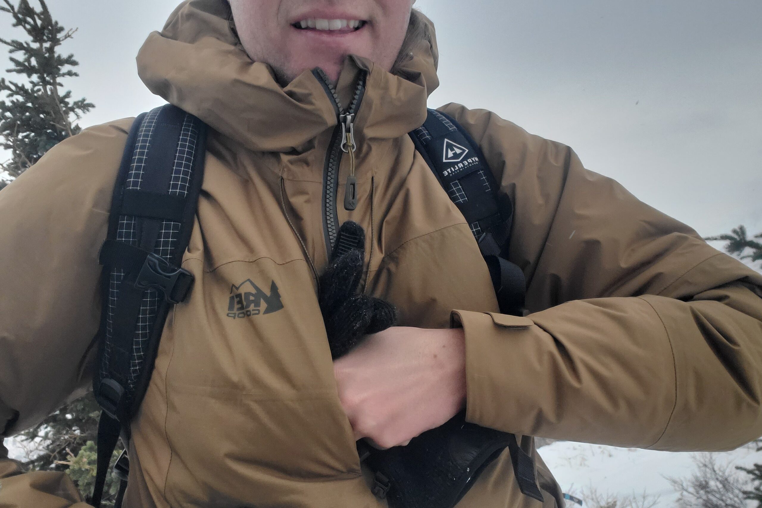 A closeup of a man putting a pair of gloves in the chest pocket of his jacket.