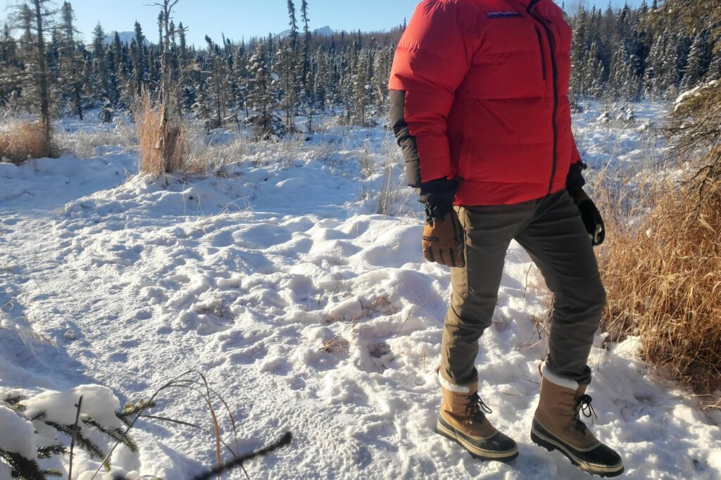 A closeup of a man walking down a trail in winter.