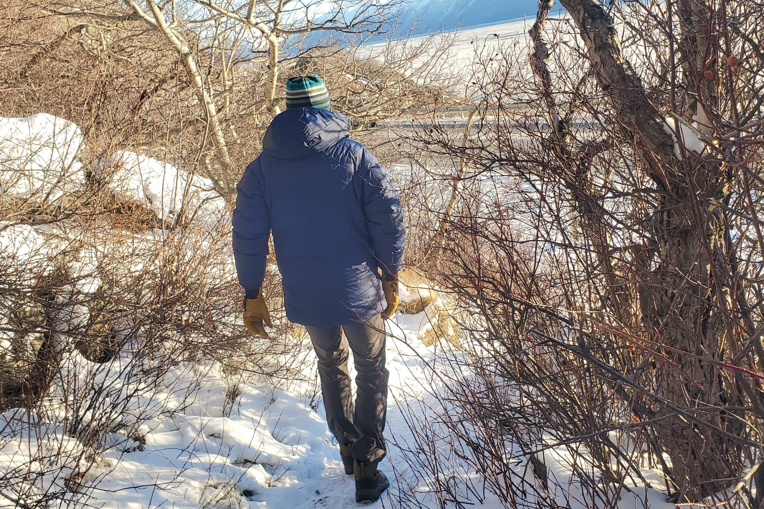 A man walks down a snowy trail