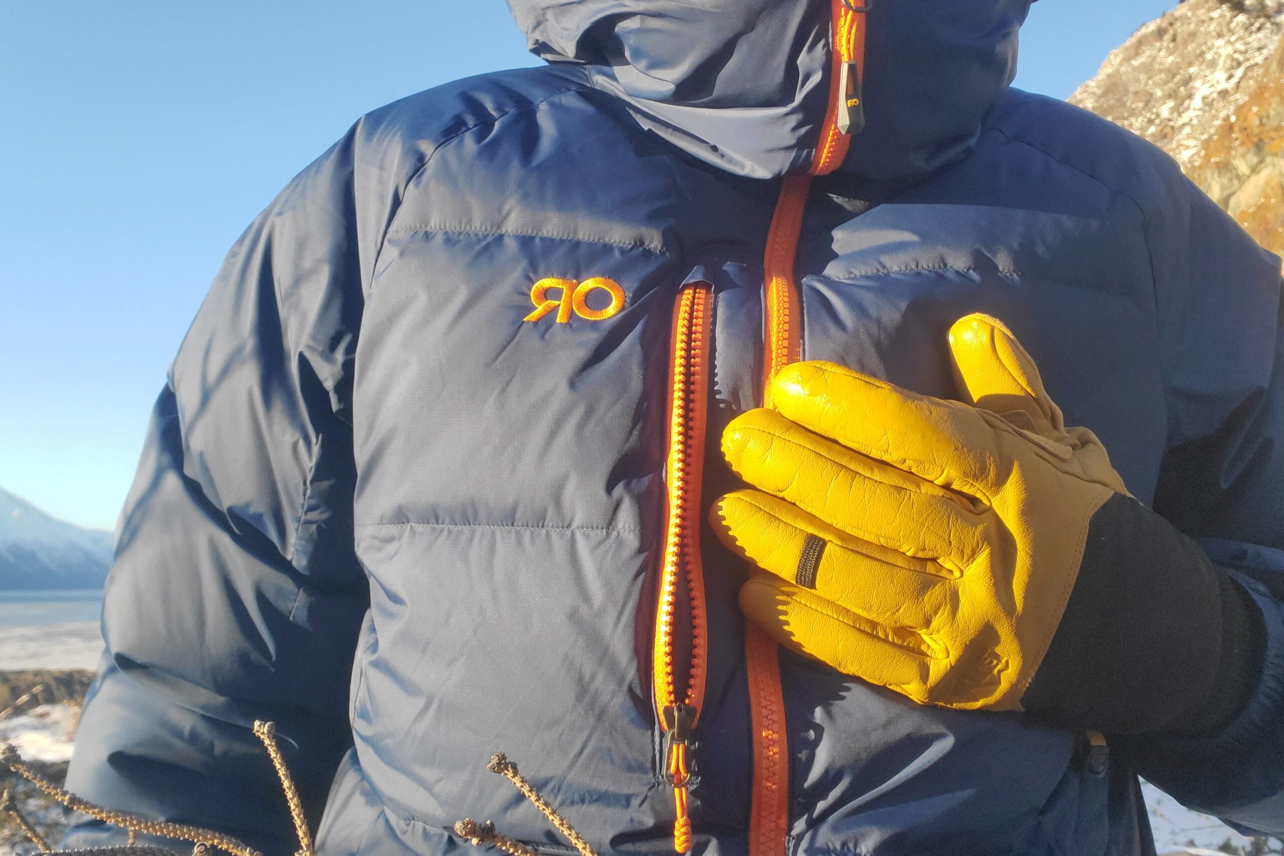 A closeup of a pair of gloves in front of a jacket