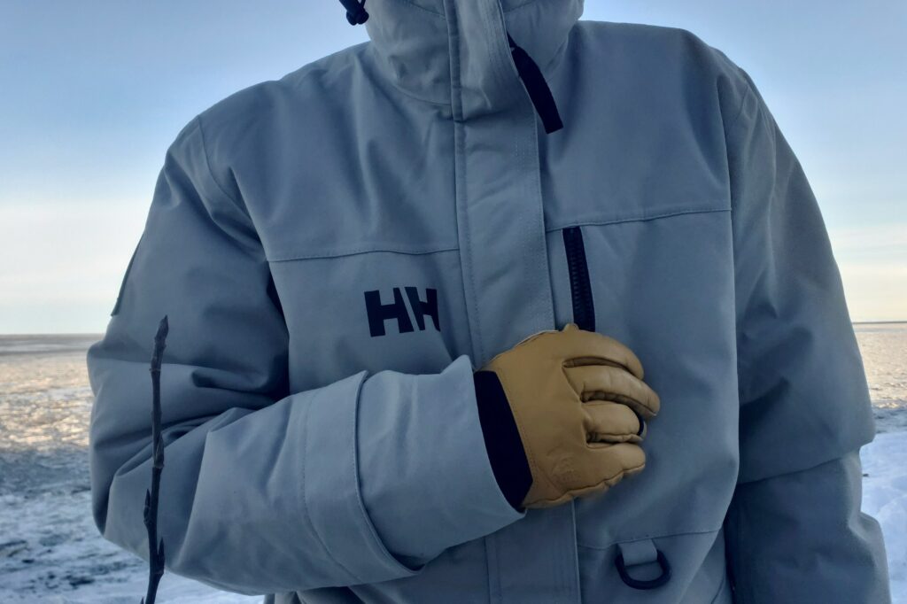 A man unzips the chest pocket of his winter jacket.