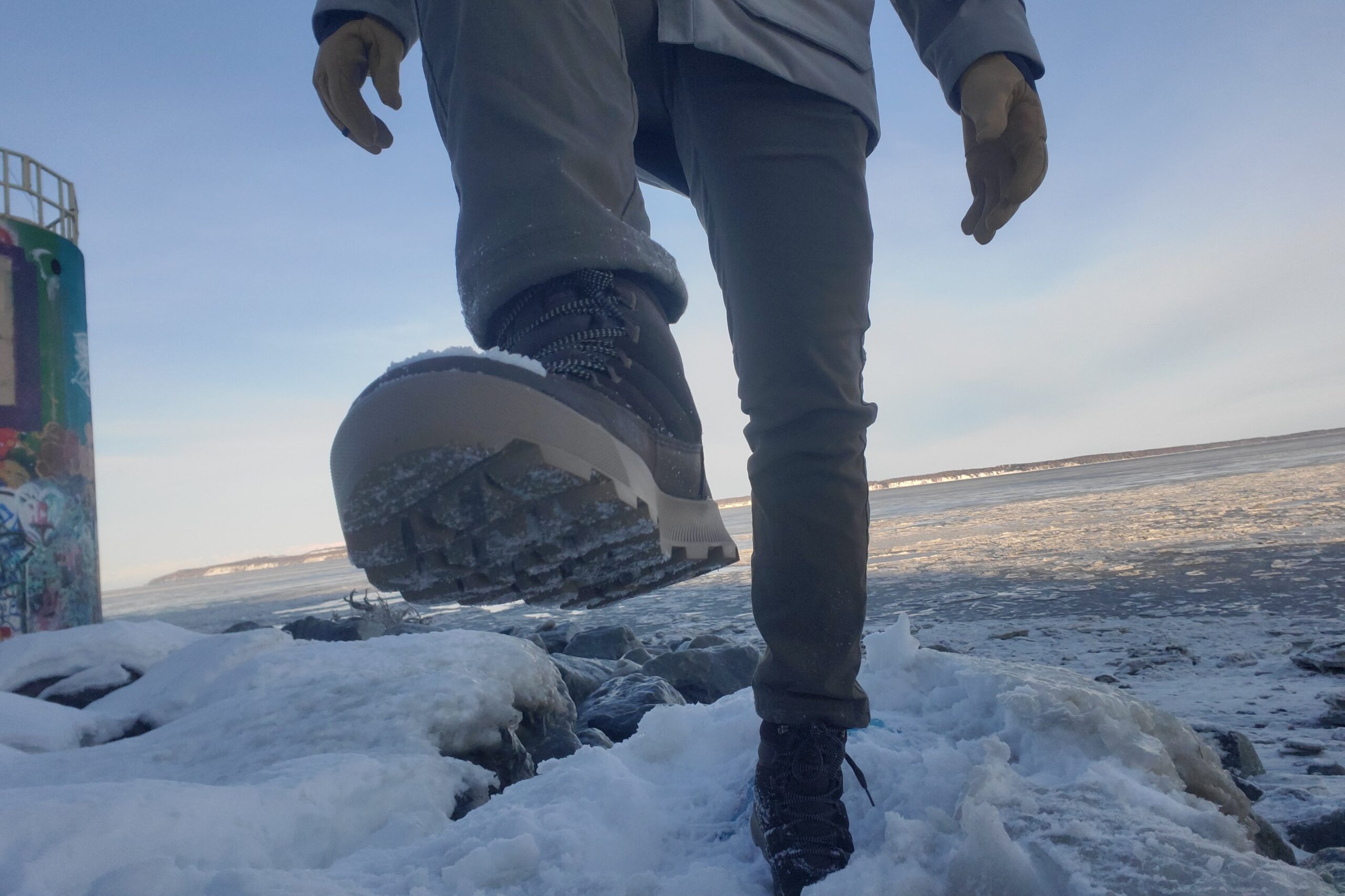 A man takes a step up showing the lugs of a pair of hiking boots.