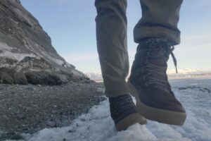 A man balances on ice along a steep embankment.