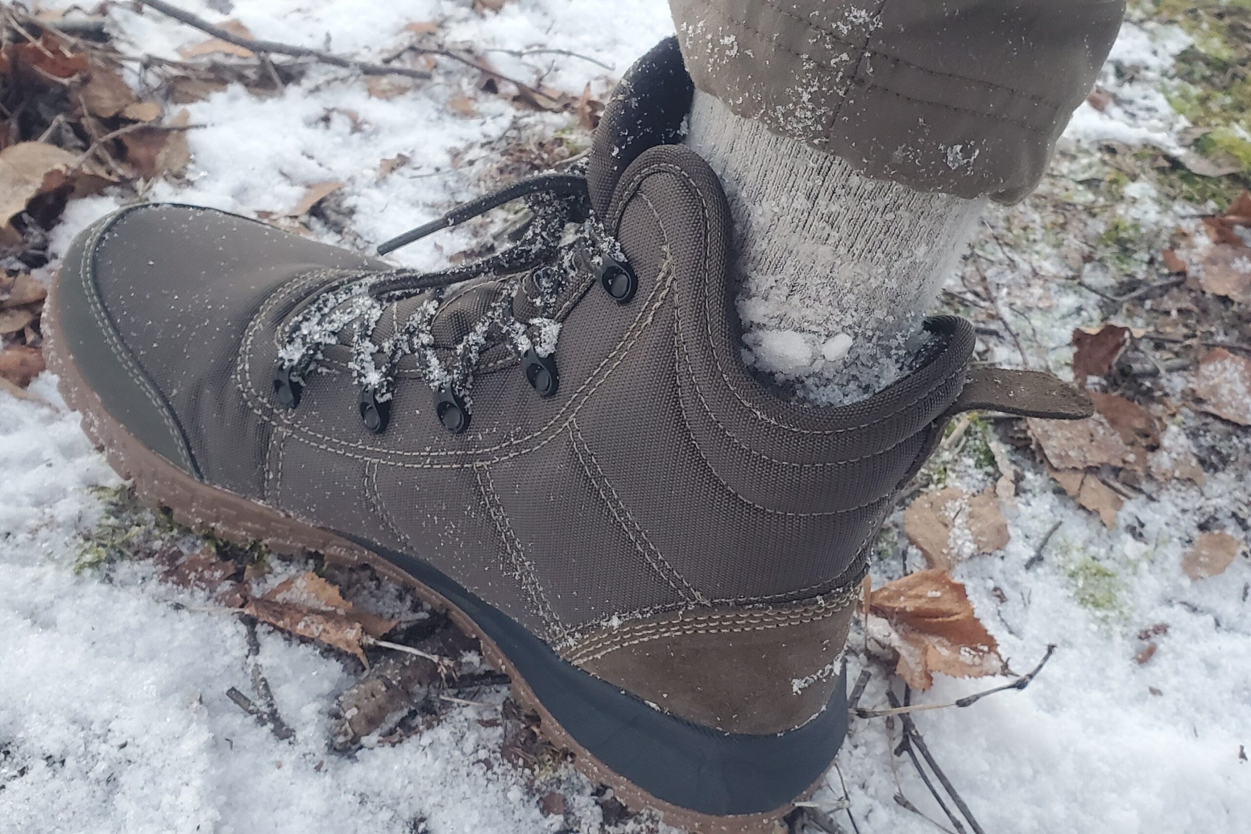 A closeup of a winter boot showing where snow has entered the boot.