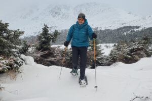 A woman walks through a deep snow drift.