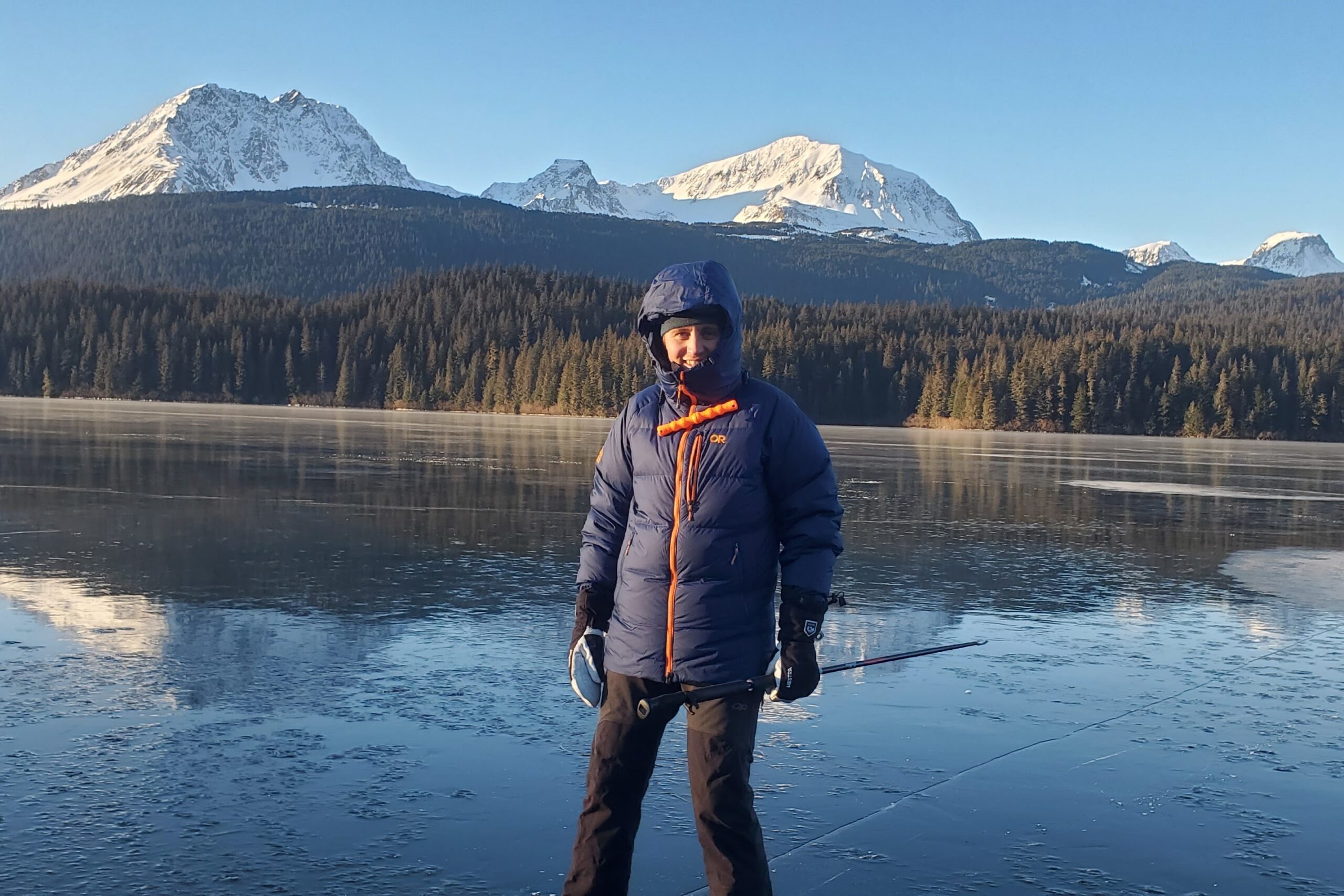 A man ice skating with mountain views