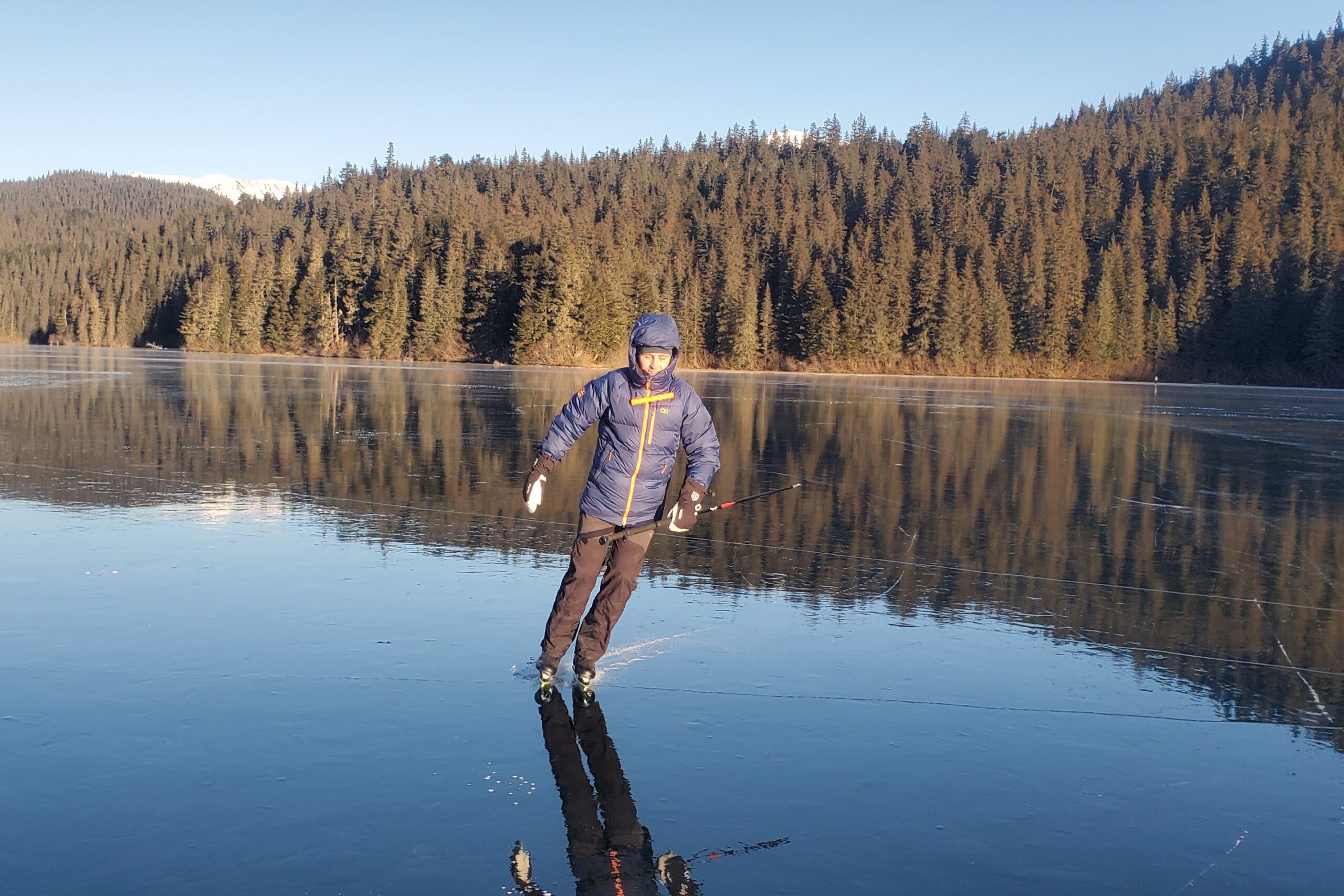 A man ice skating on smooth ice.