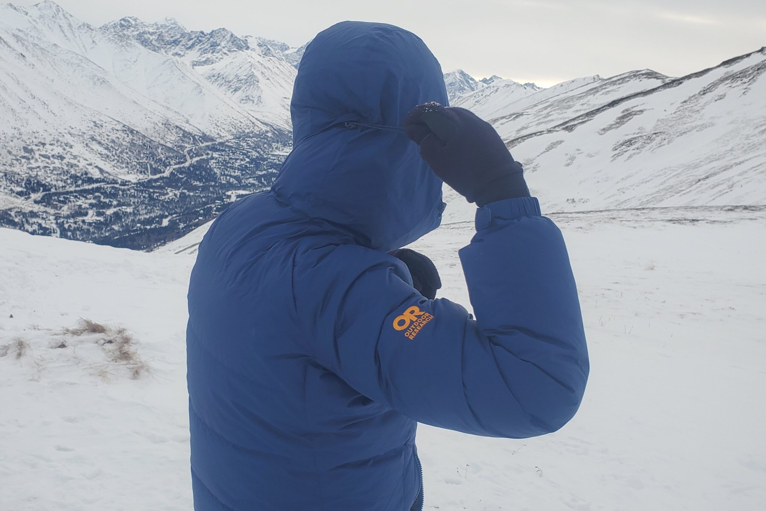 A man tightens the hood of his down jacket.