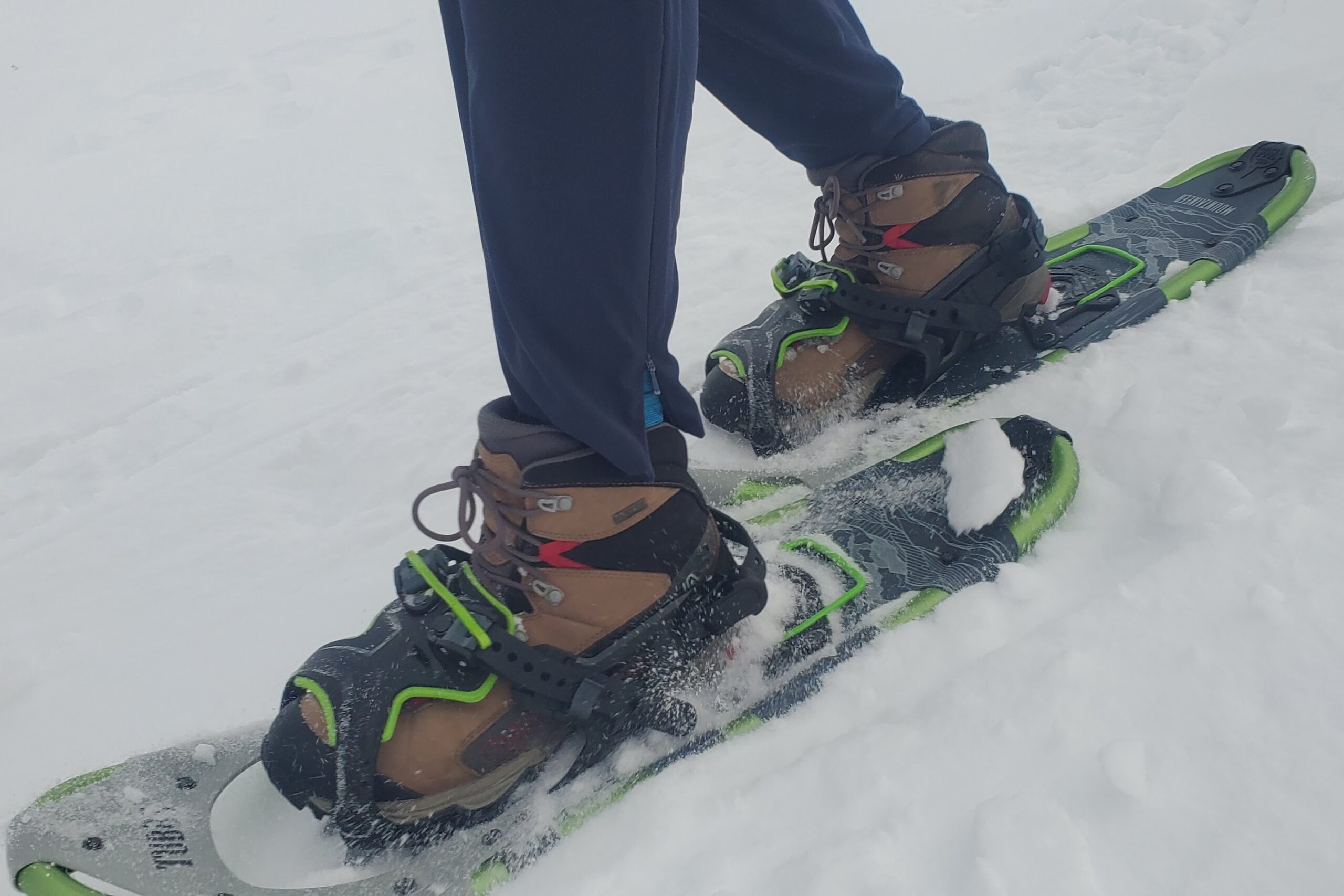 A closeup of snowshoes walking downhill