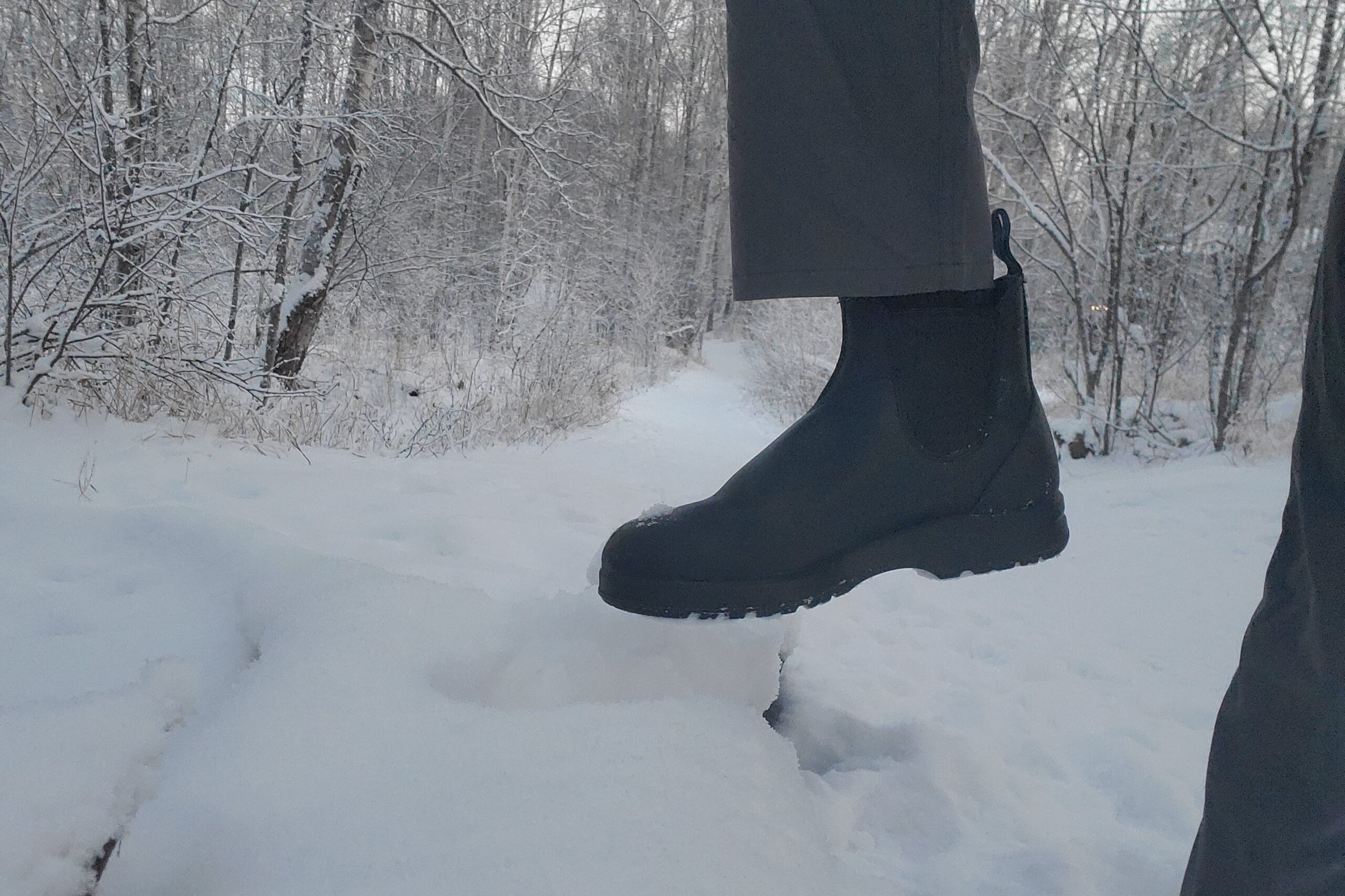 A closeup of boots stepping onto a log