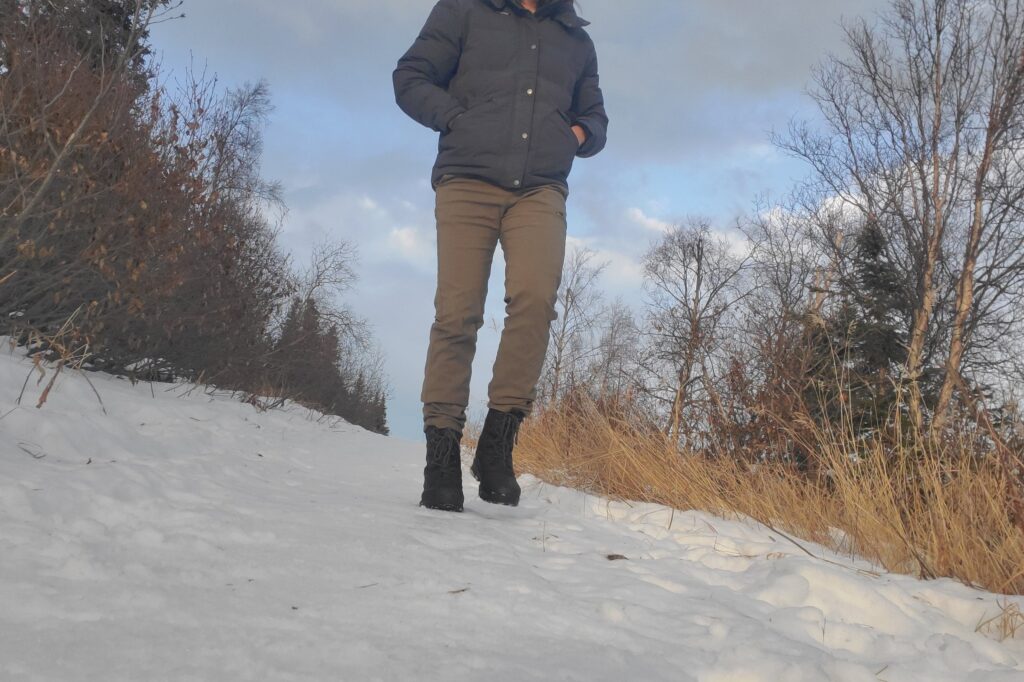 A man walks down a snowy trail.