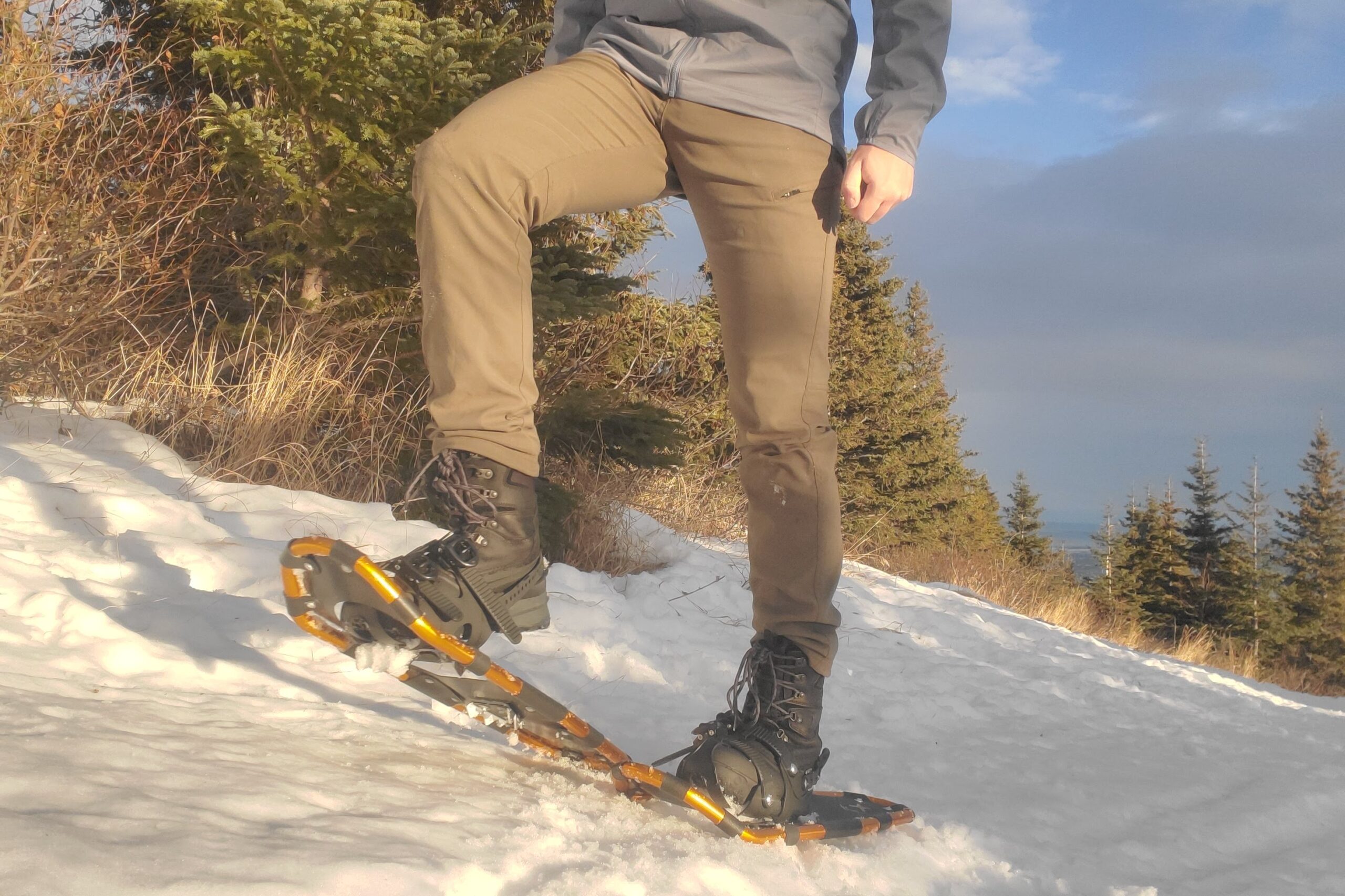 Snowshoes walking in the sun on a snowy trail.