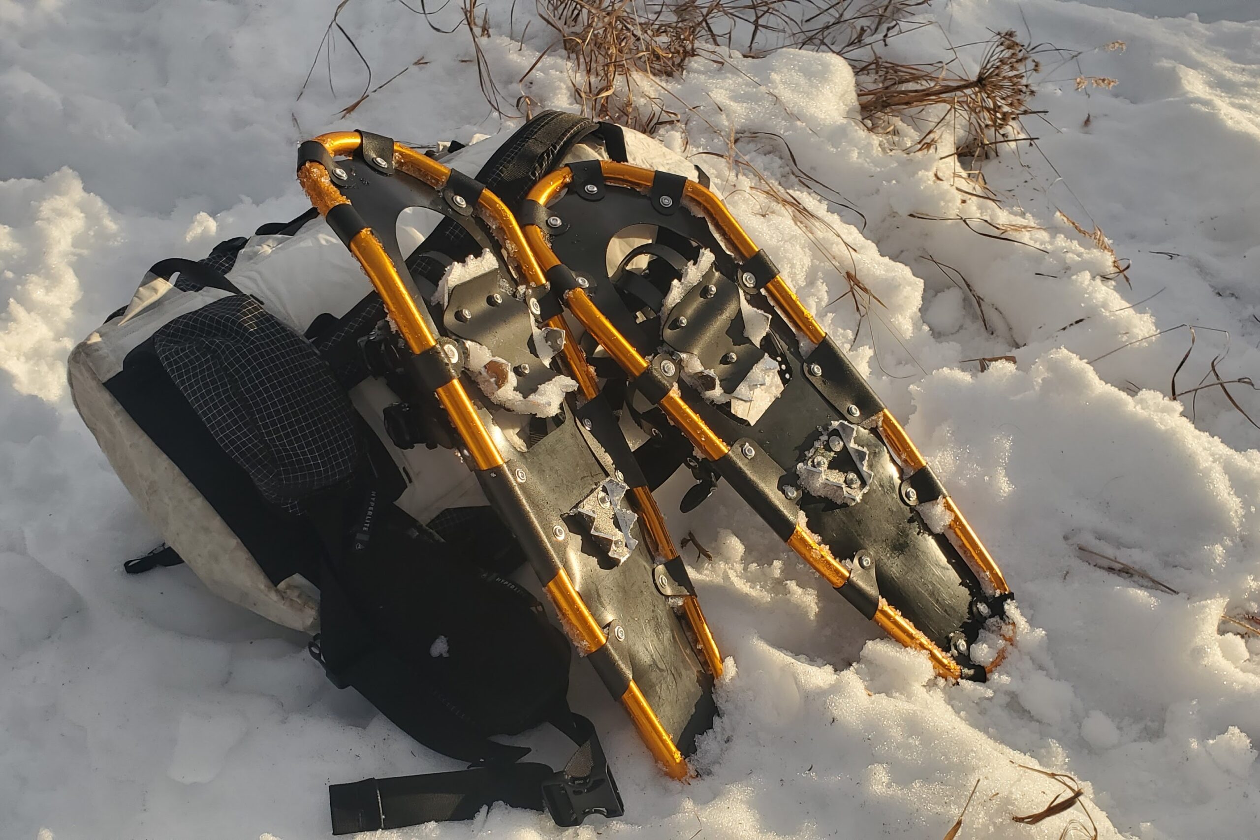 A pair of snowshoes leans against a backpack.