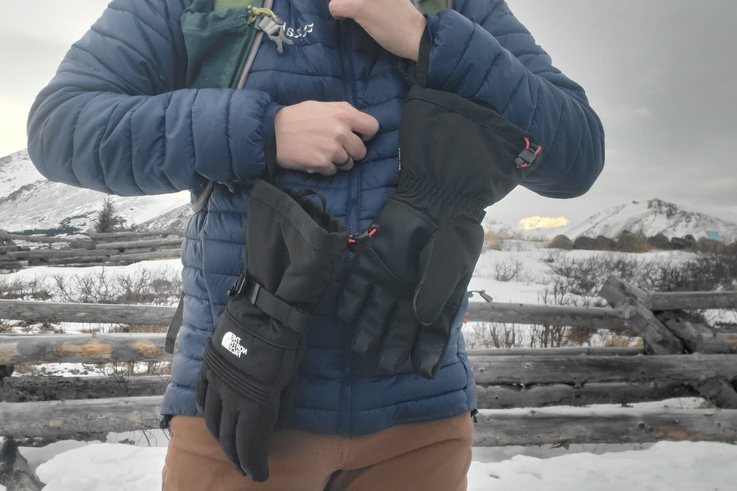 A closeup of gloves hanging from leashes secured to the wrist.