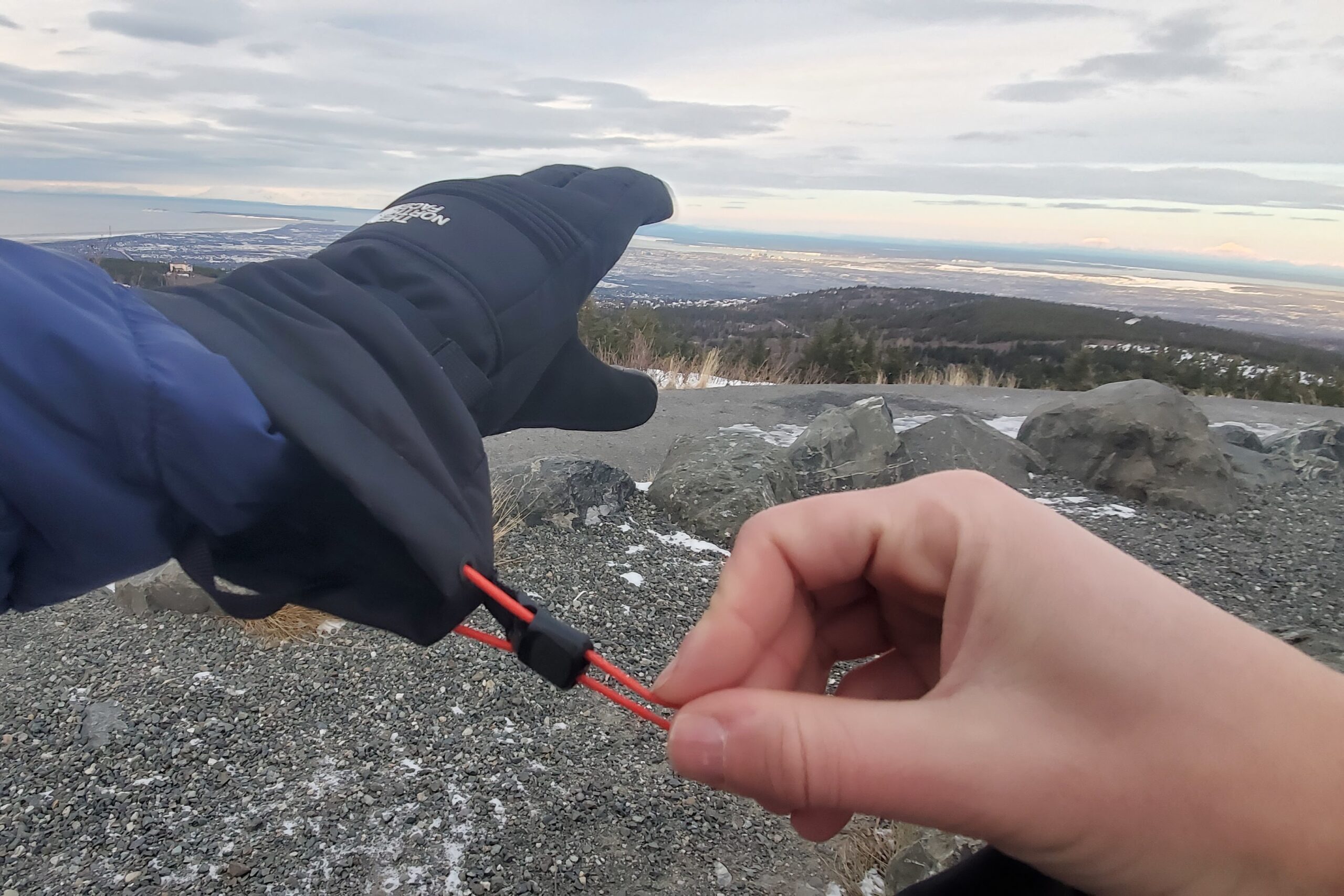 A closeup of hands tightening the cuffs of winter gloves.