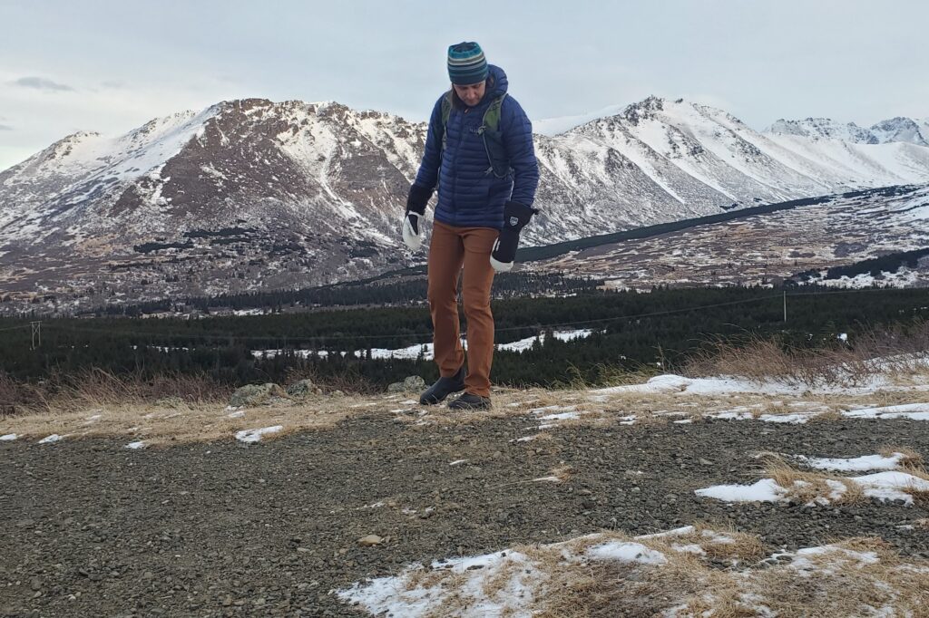 A man walking with mountain views in the background.