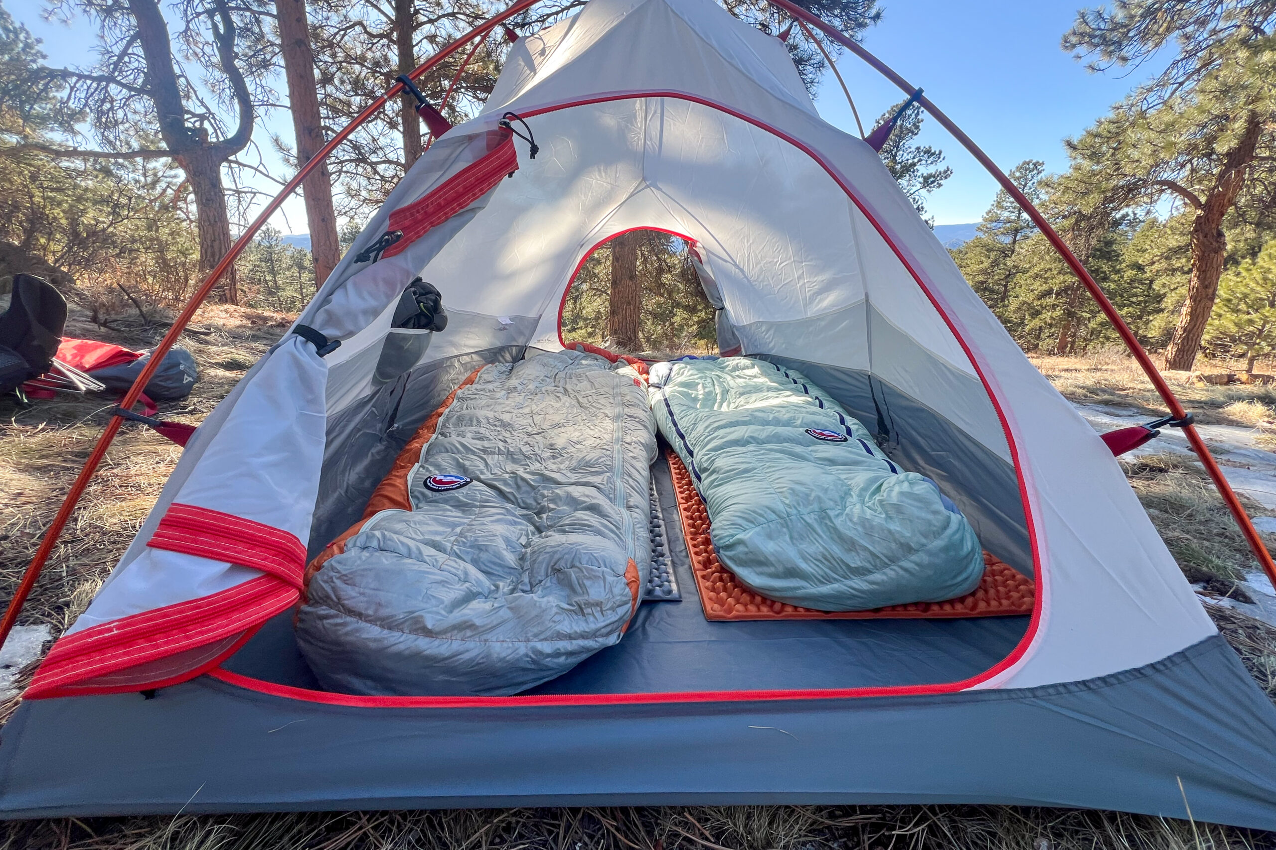 Two sleeping pads and bags set up inside the Alps Mountaineering Tasmanian 2 tent, illustrating its interior layout and gear storage options.