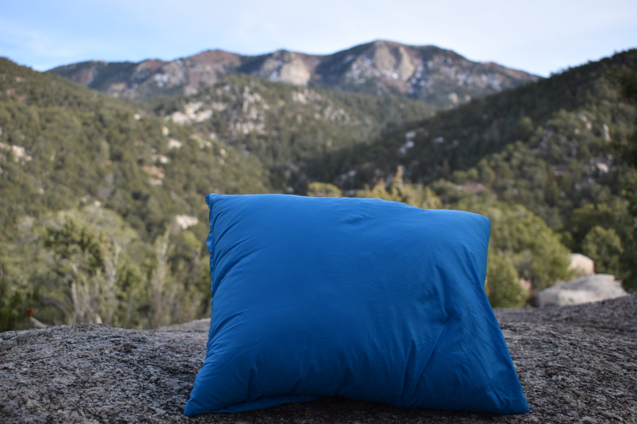 Cloudrest Down Pillow propped up with the Sandia Mountains in the background