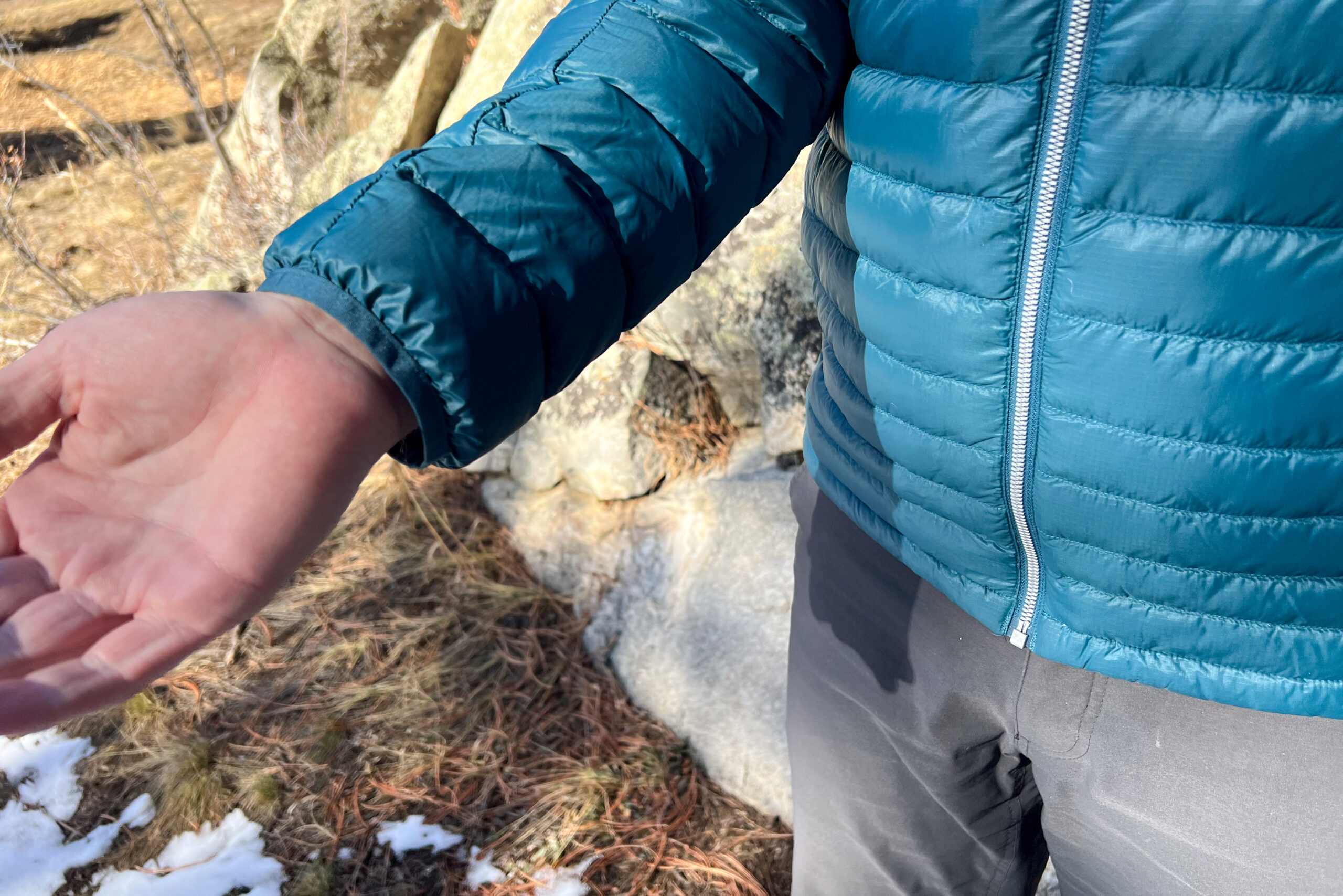 Close-up of the Cotopaxi Fuego's cuff, showing its non-adjustable, wide design on a person's outstretched arm.