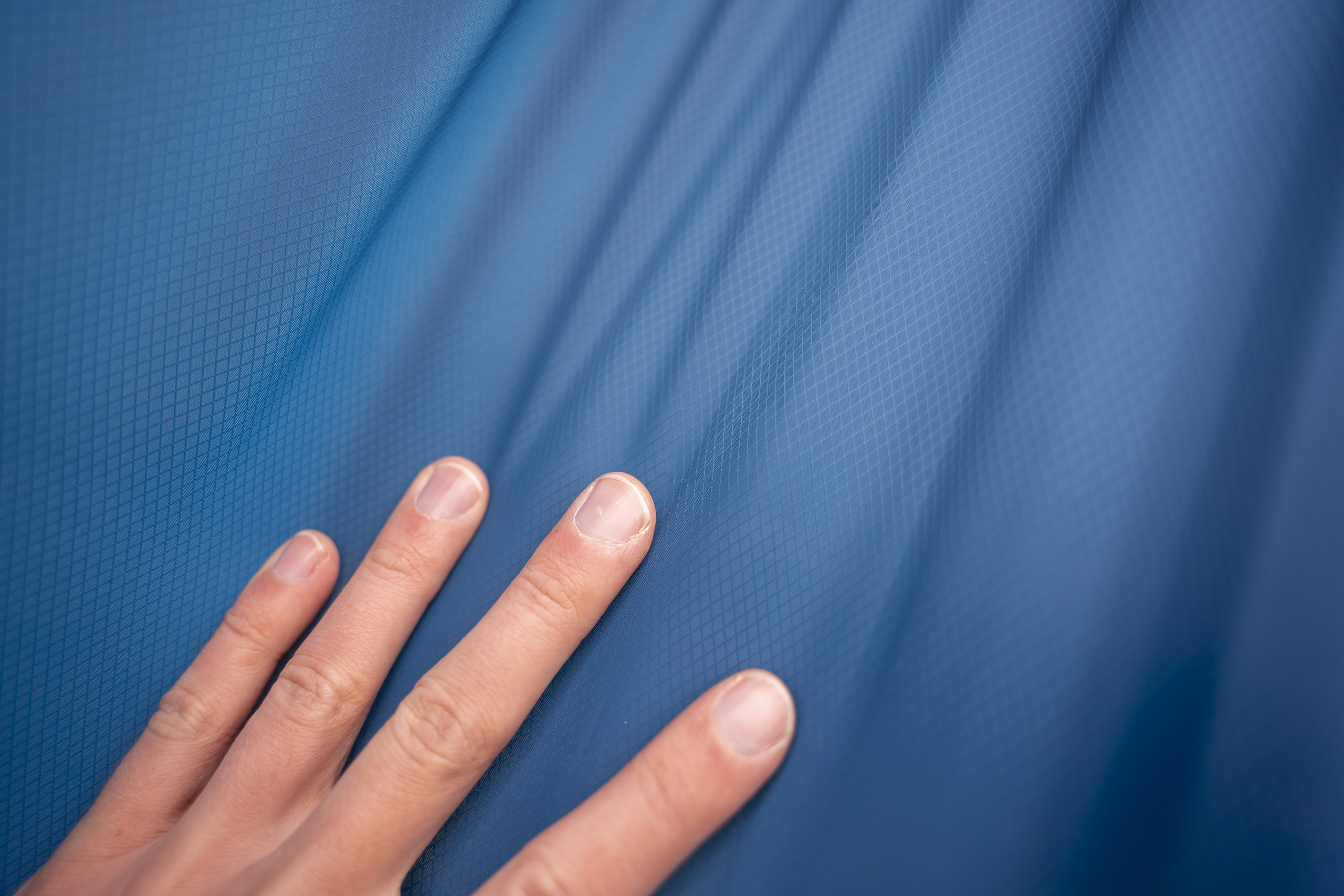 a hand rests on blue fabric