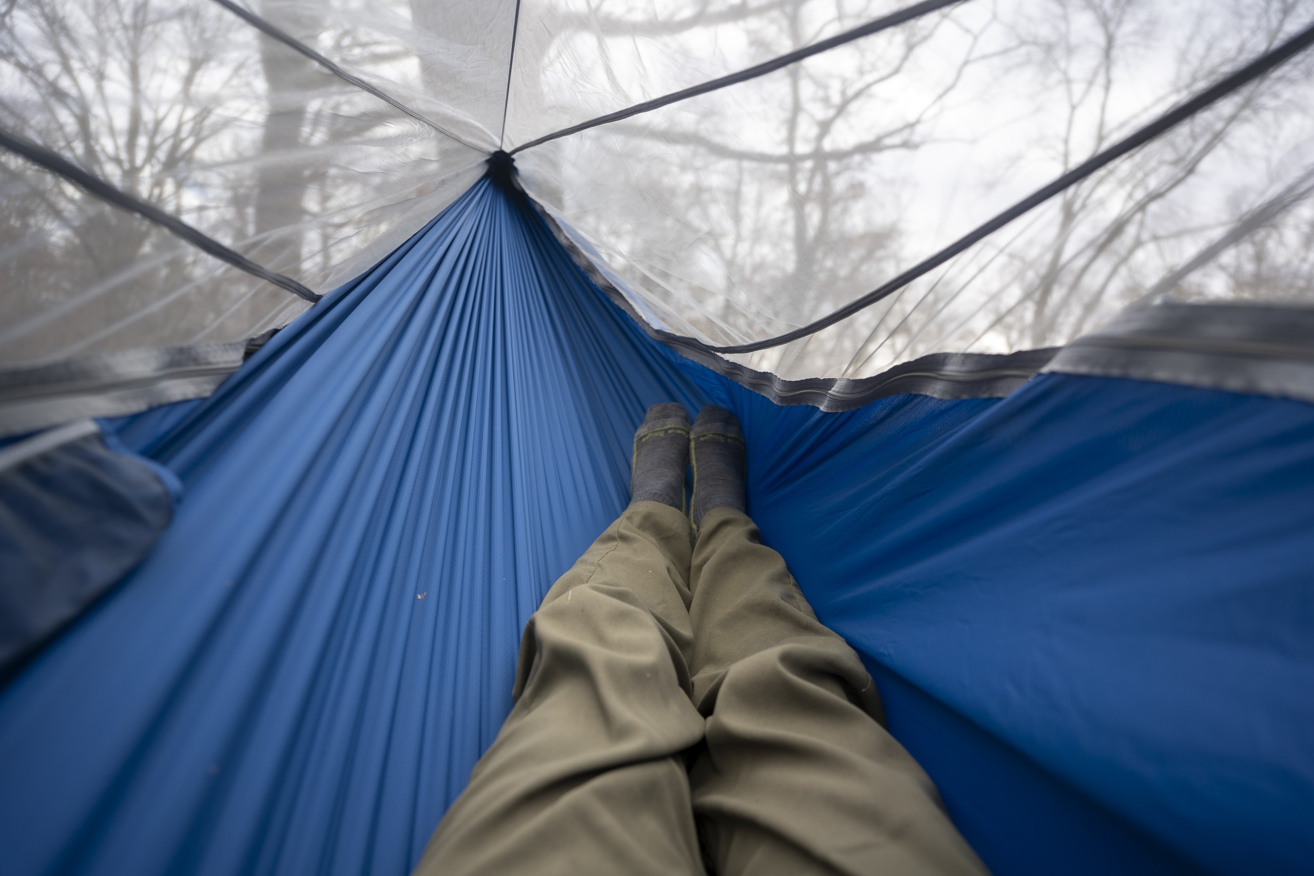 a pair of legs extend into a hammock body from a point of view perspective