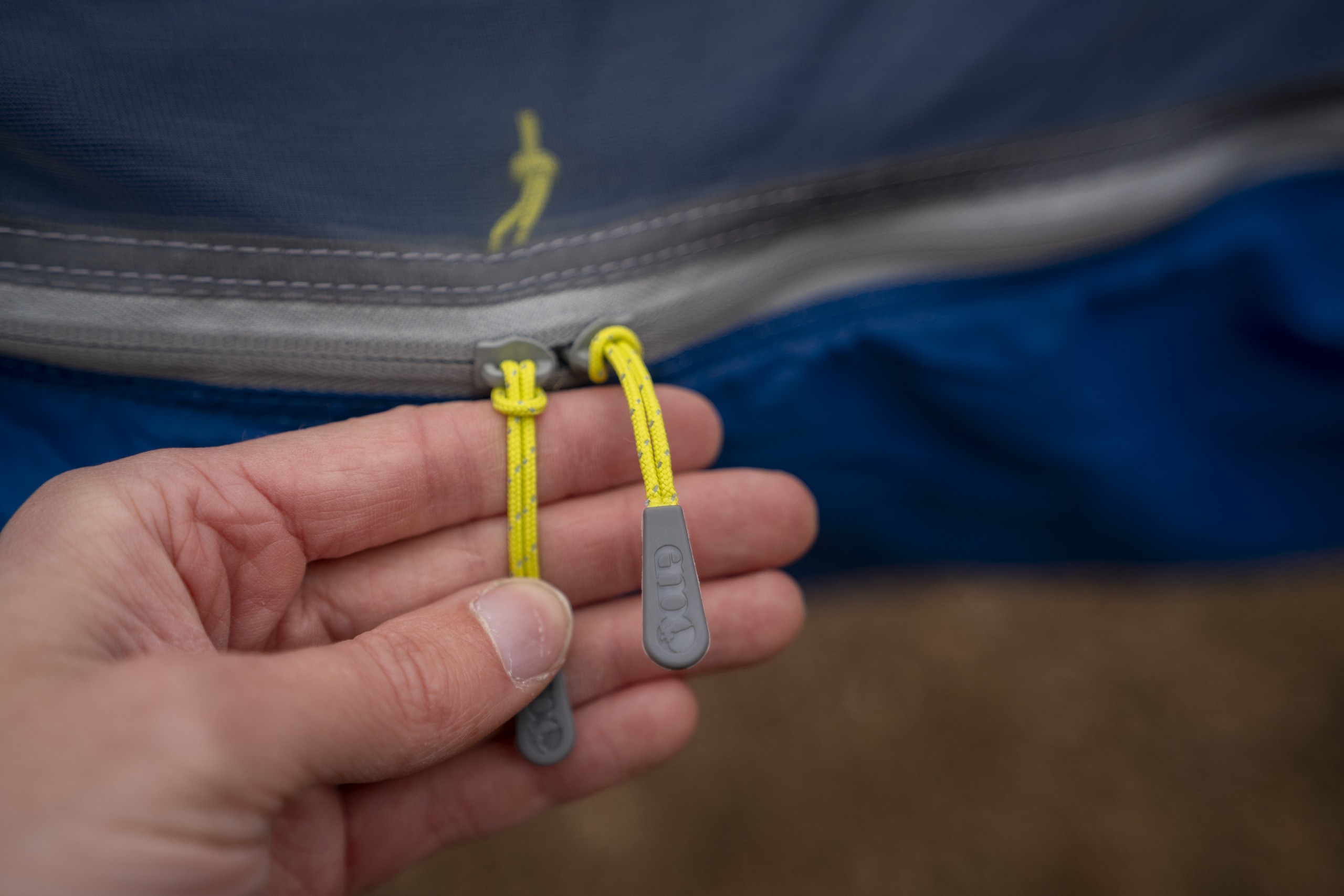 a hand holds hammock zipper pulls