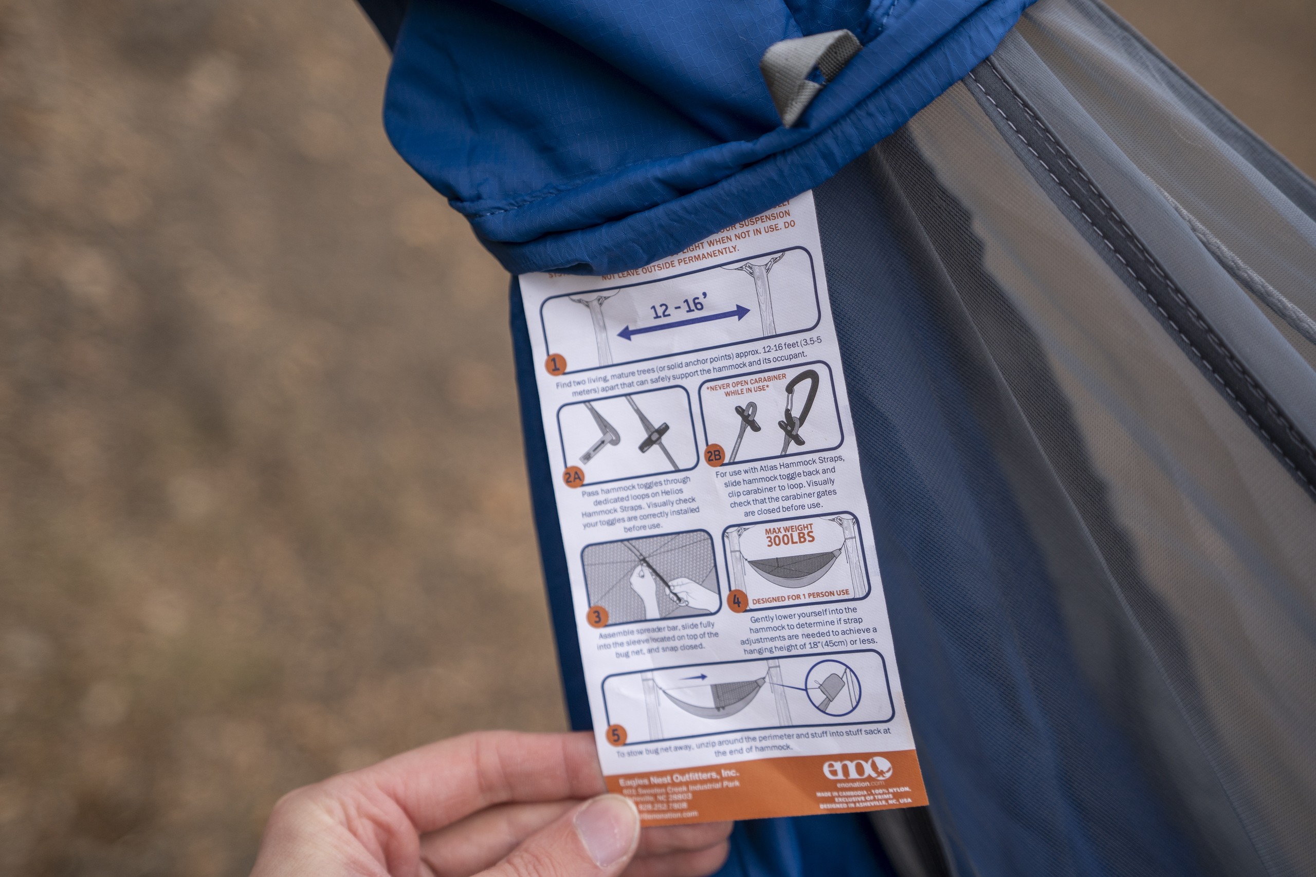 a hand holds instructions for setting up a hammock