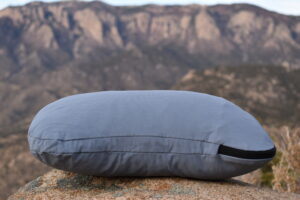 HEST camp pillow on a rock with mountains in the backgroun