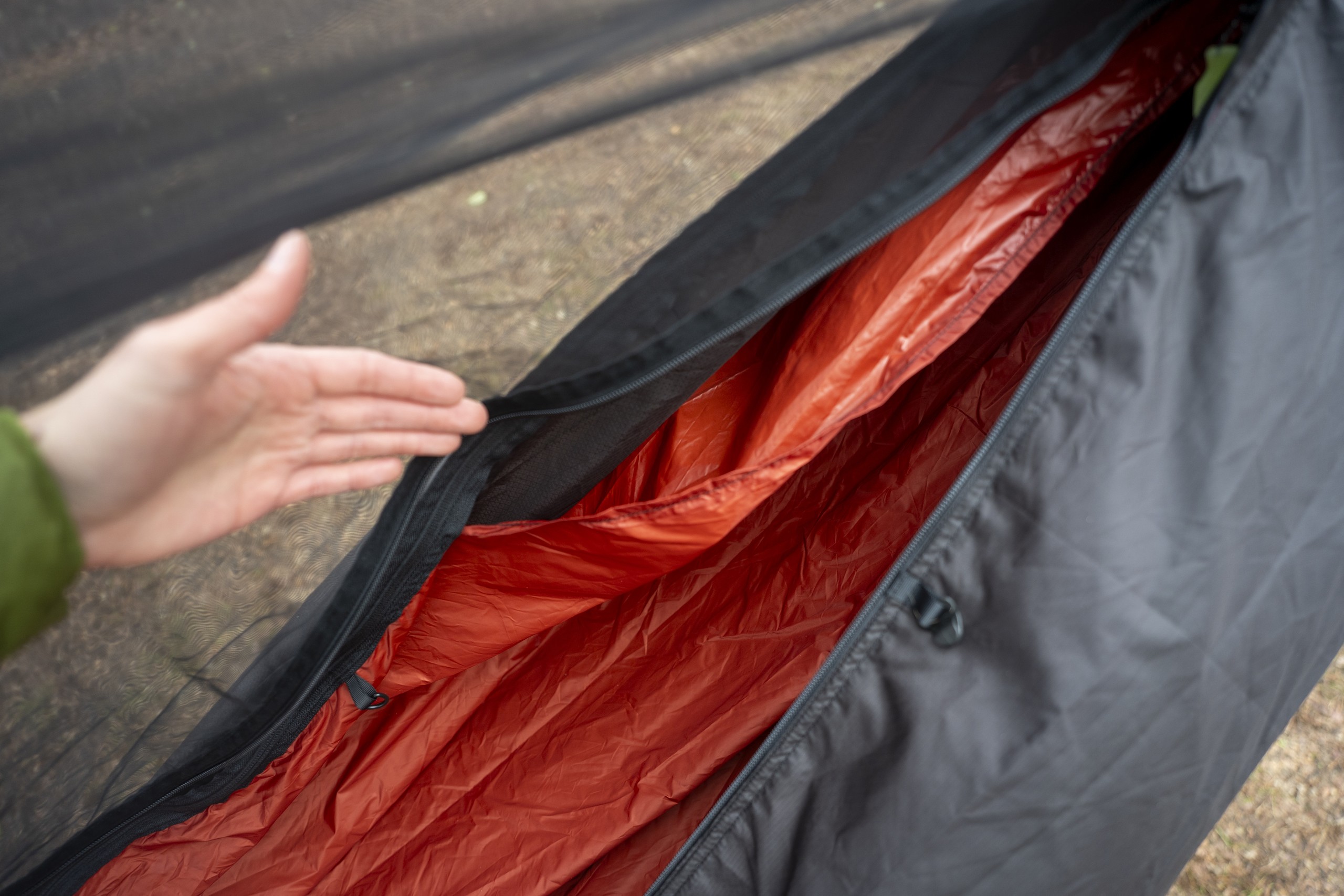 A hand highlights a double layer hammock fabric