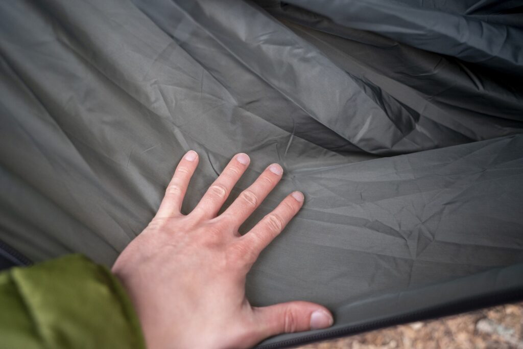 a hand rests on green nylon fabric