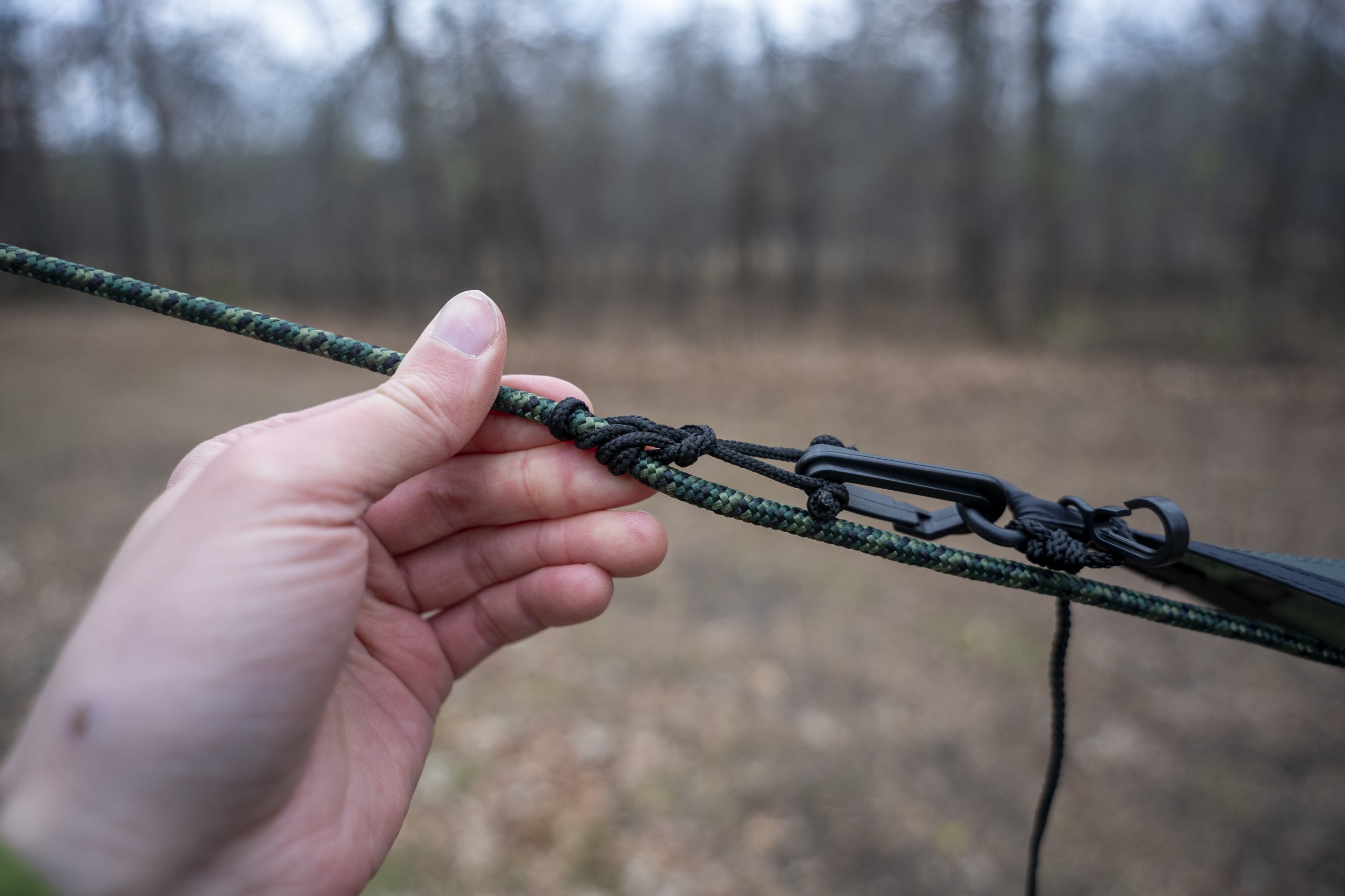 a hand holds a hammock suspension