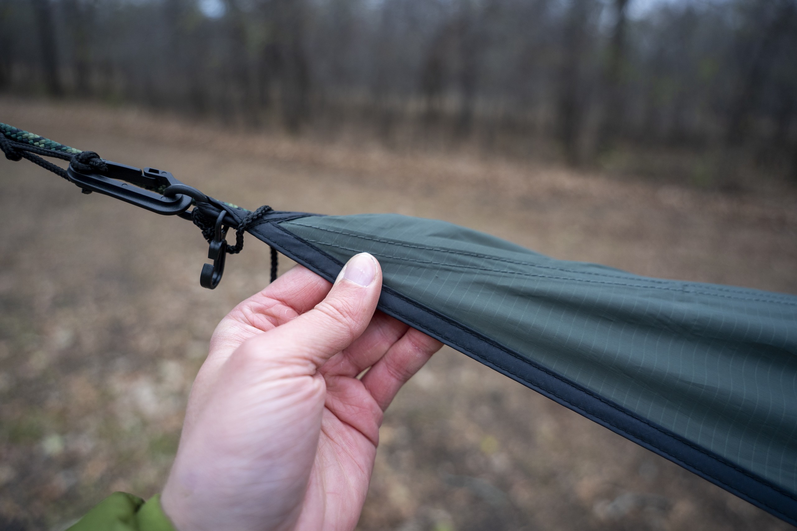 a hand holds the end of a hammock