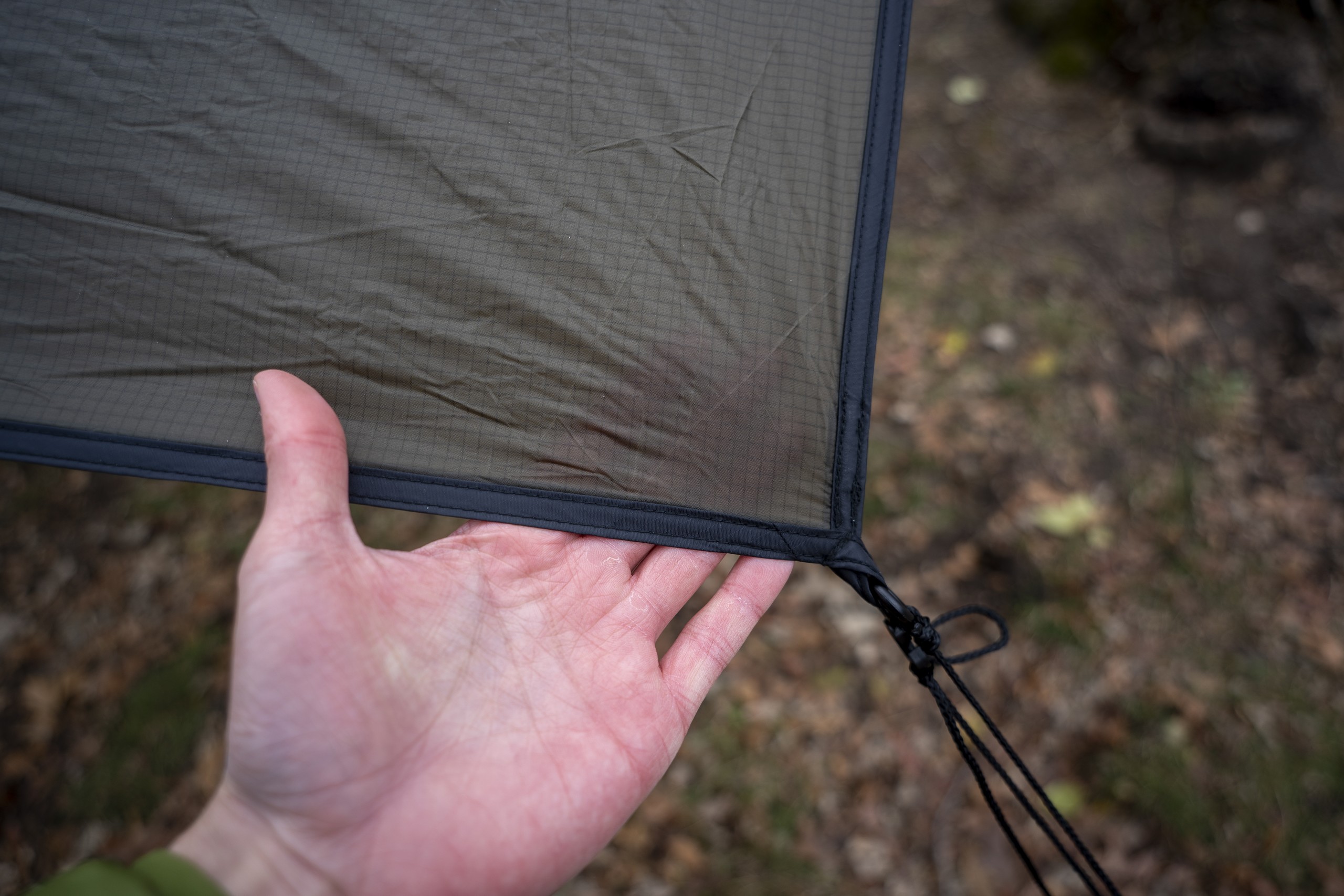 a hand holds the corner of a tarp