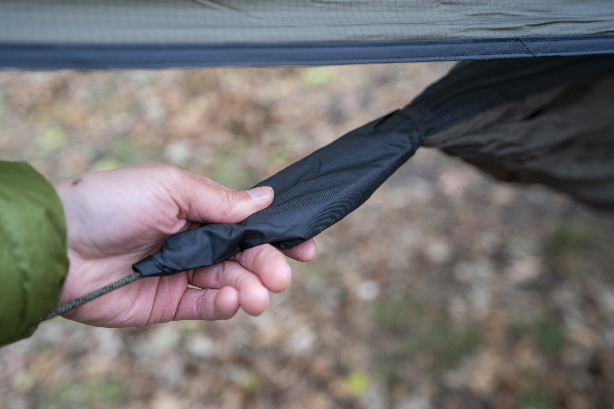 a hand holds the end of a hammock