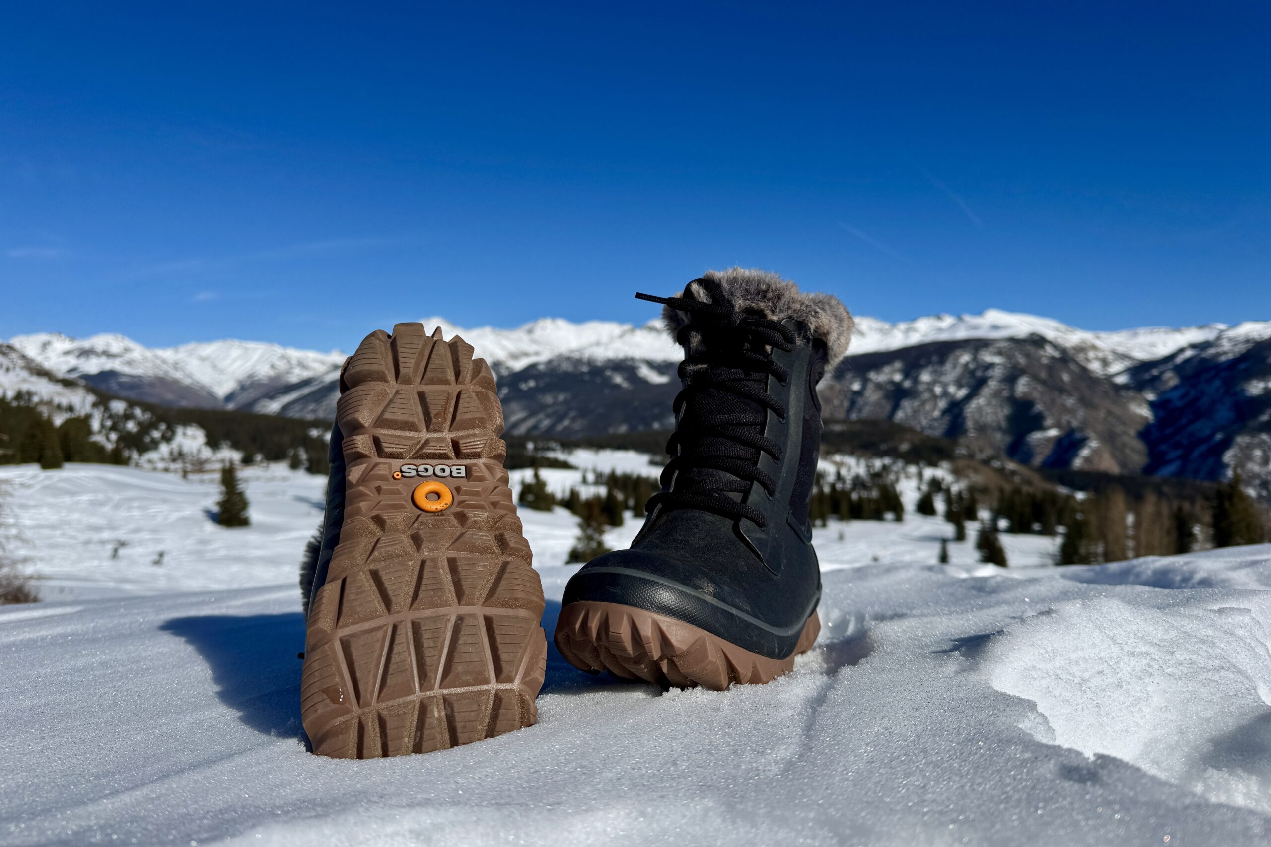 A close up of the tread on the bottom of the Bogs Arcata boot. It is sitting in the snow in the mountains.