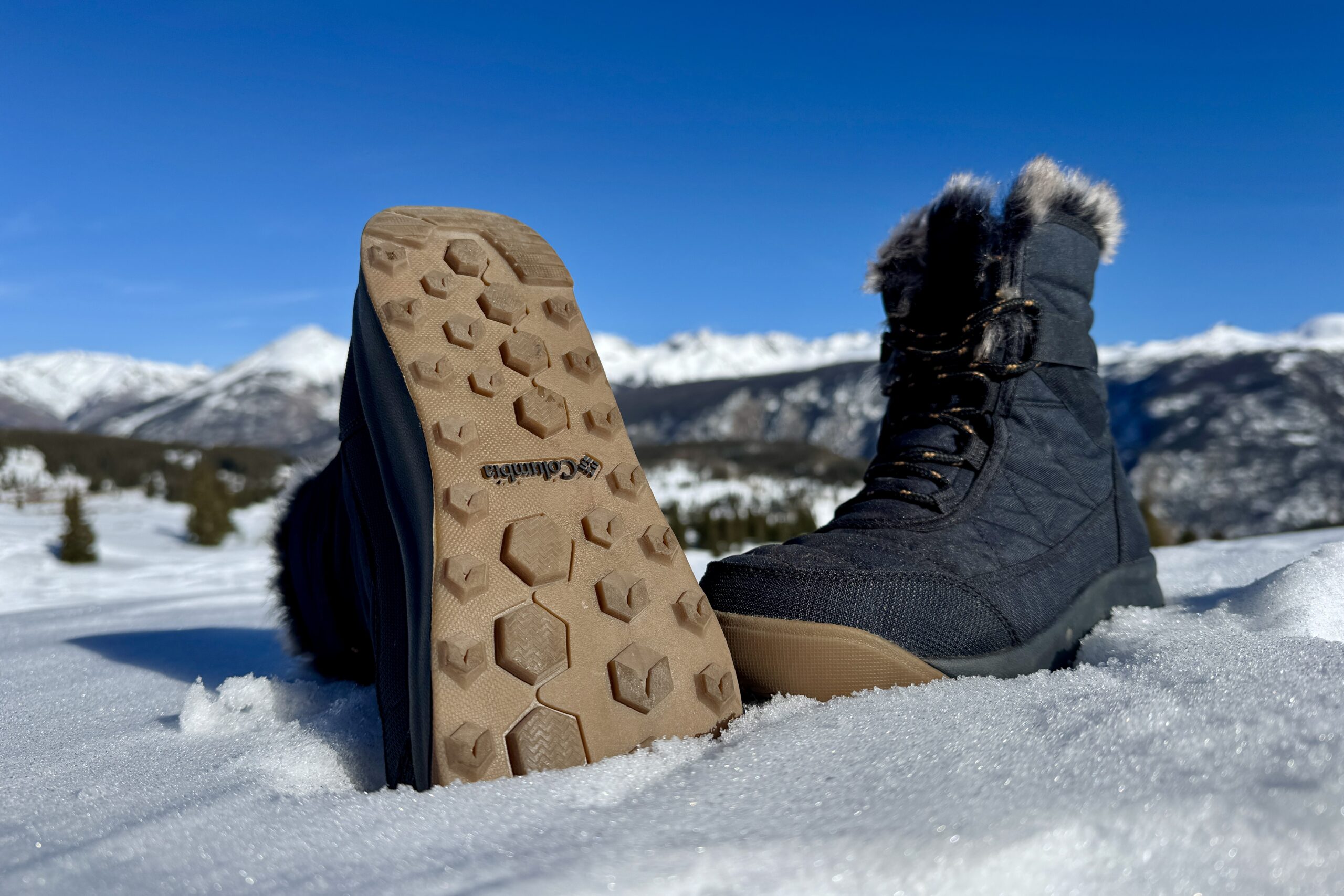 A close up of the tread on the bottom of the Minx Shorty boot. It is sitting in the snow in the mountains.