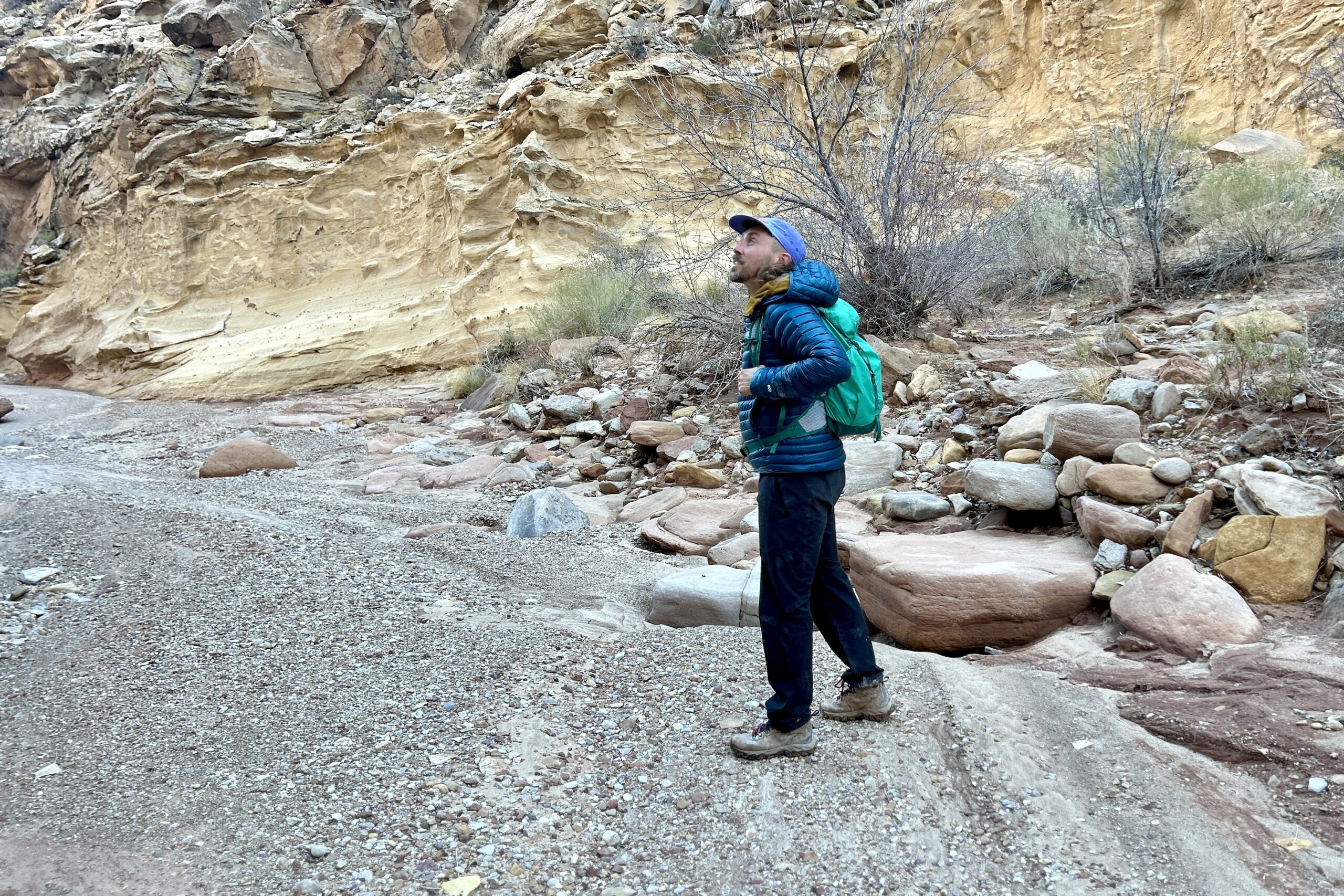 A man hikes through a desert canyon.