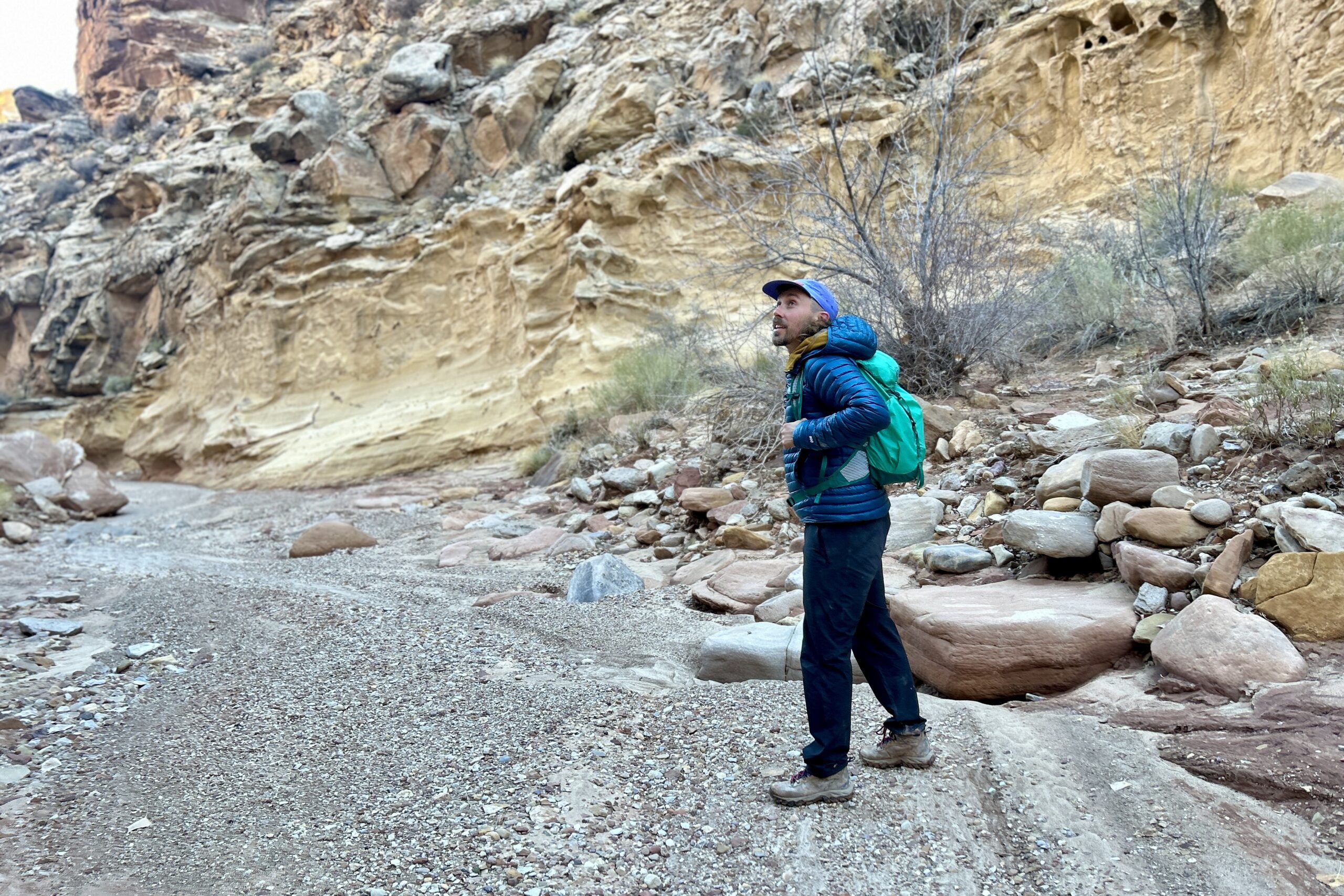 A man hikes through a desert canyon.