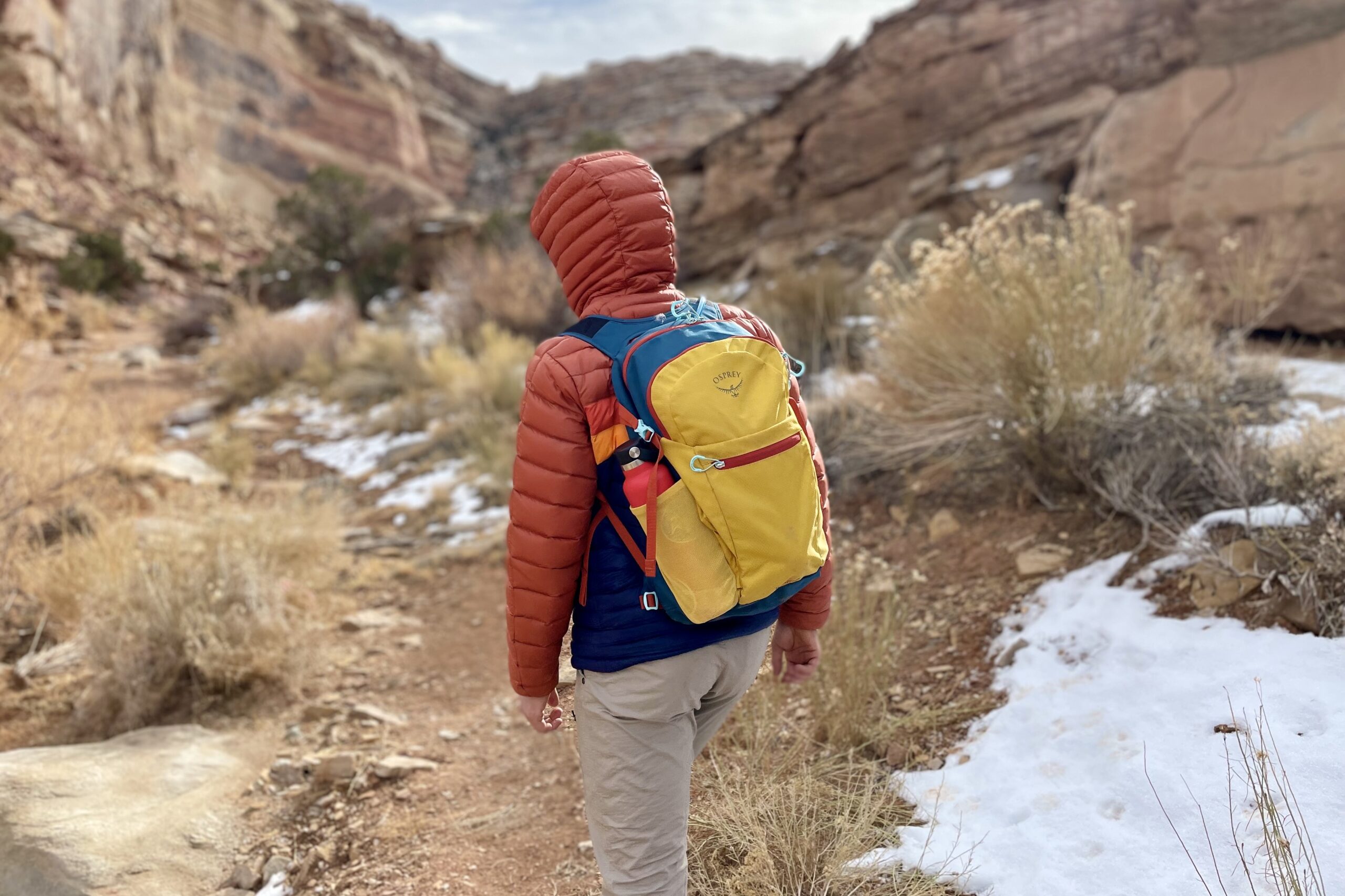 A man hikes through a desert canyon.