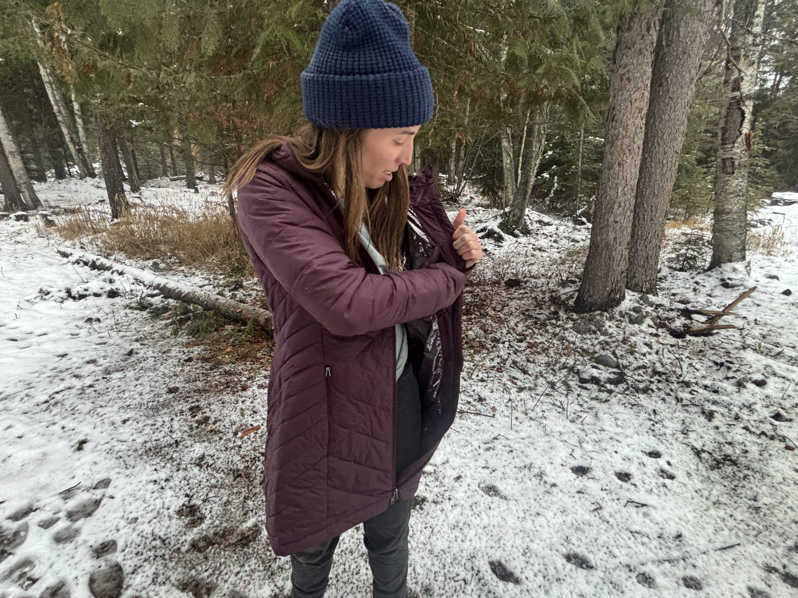 a women places something in the inside chest zipper pocket on the columbia heavenly jacket