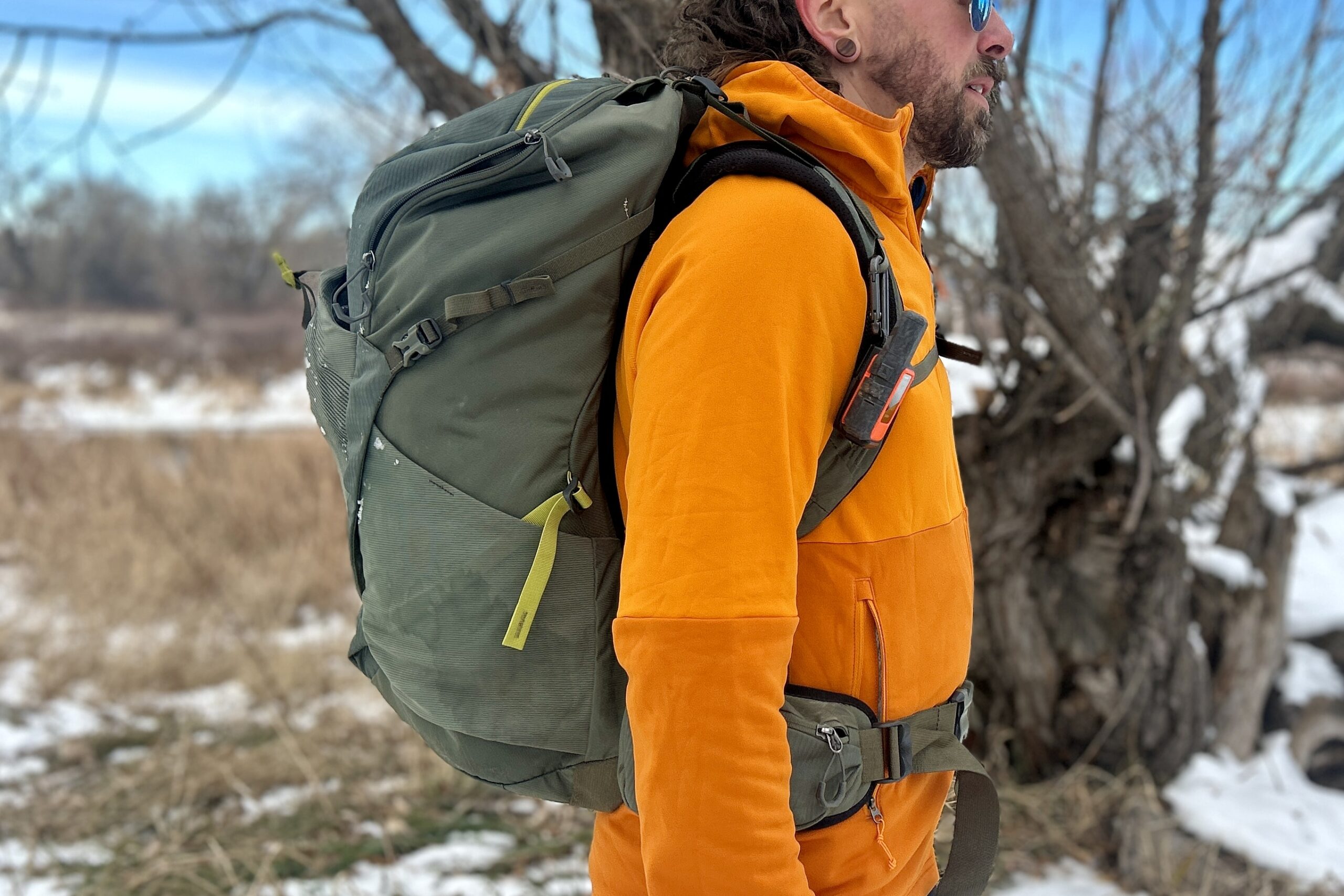 Close up of a man wearing a large daypack from the side.