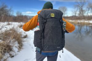 Close up image from behind of a person wearing a backpack.