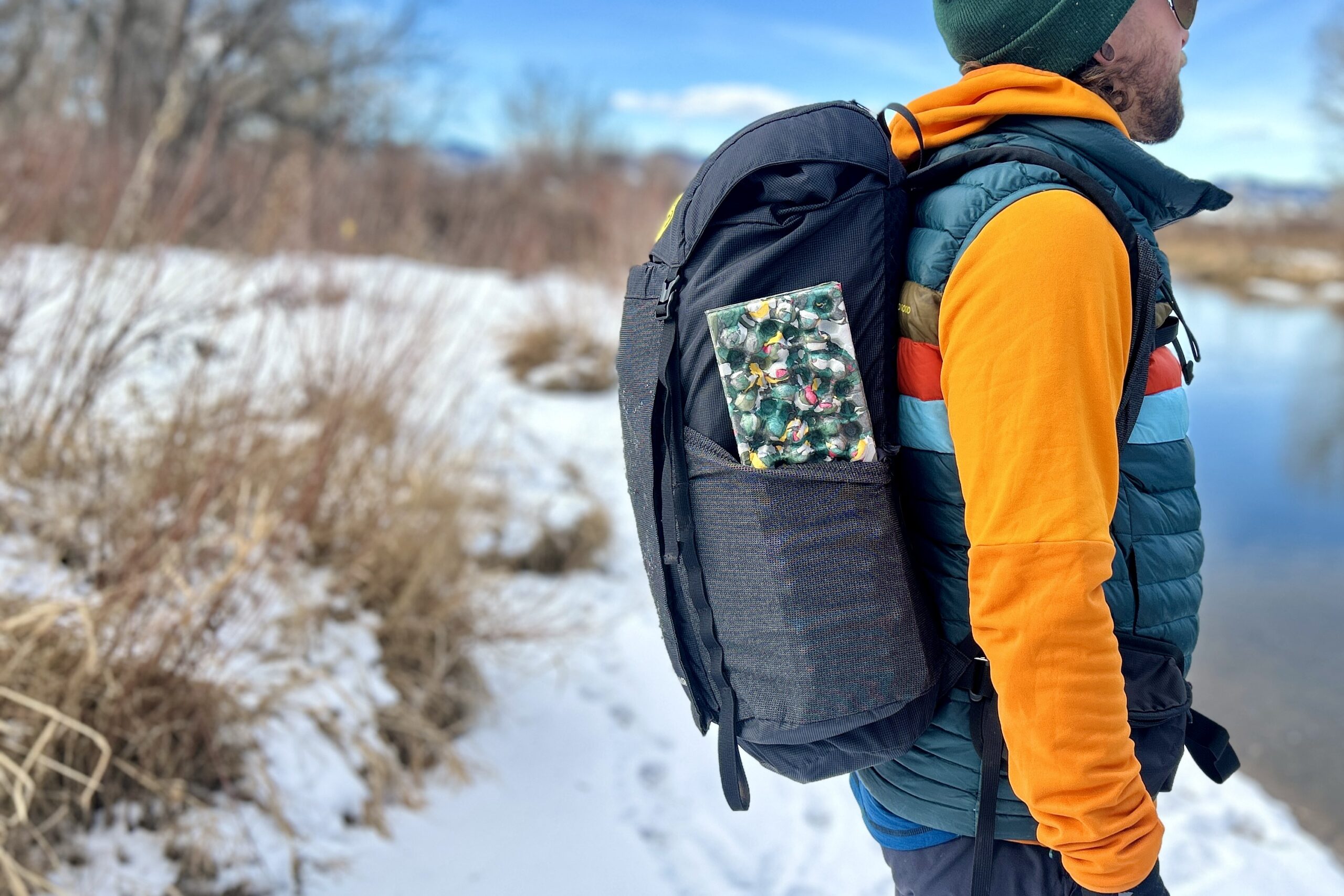 Close up image from the side of a person wearing a backpack.