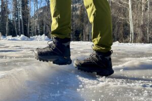 A close up of a person wearing the Thermo Chill Mids on some ice in the woods.