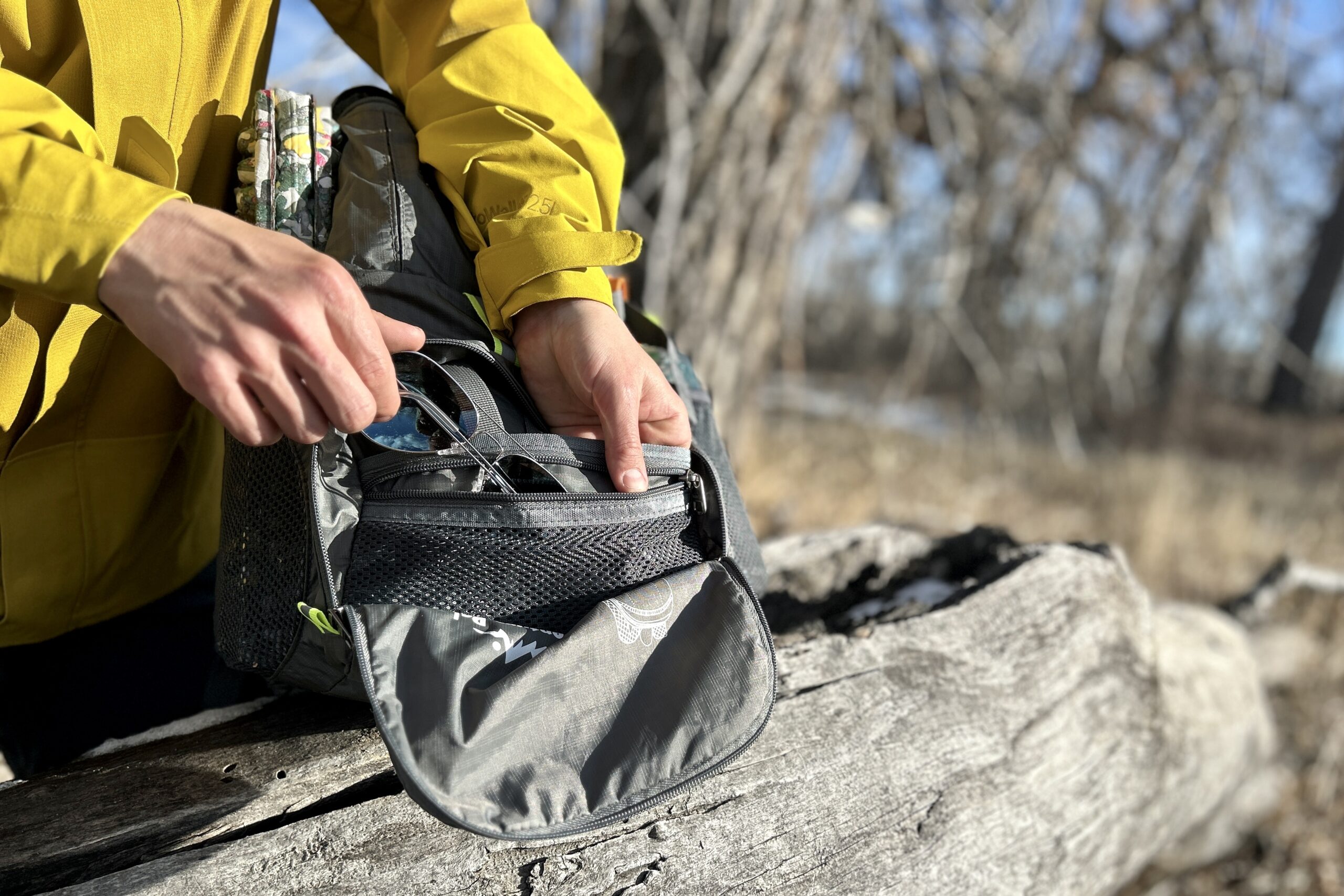 Closeup of a person pulling gear out of their backpack.